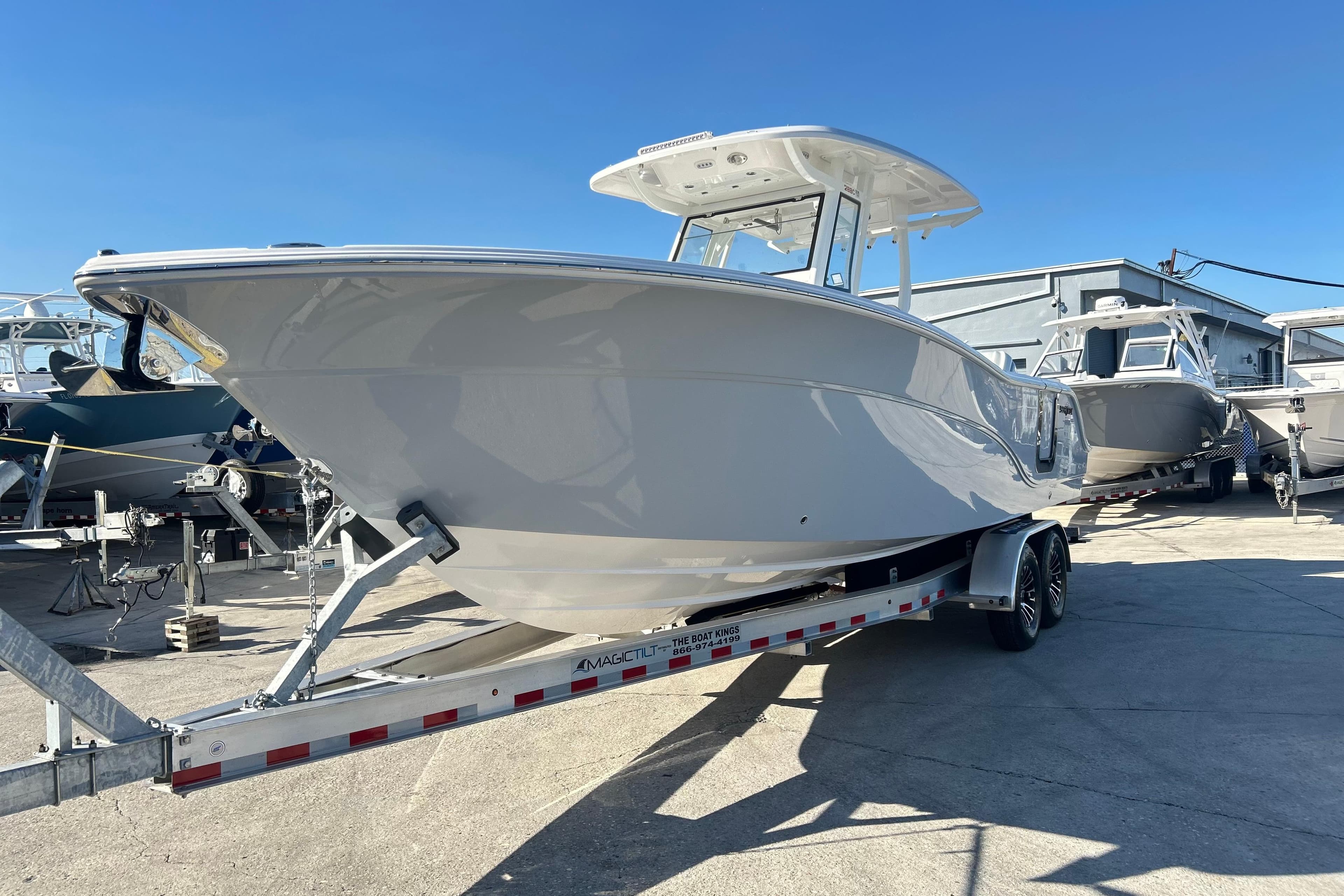 2026 Sea Fox 288 Commander boat on trailer in sunny marina setting.