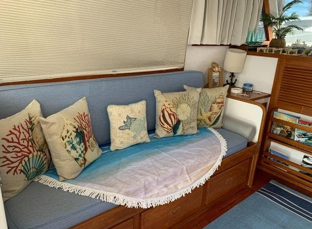 Cozy interior of 1985 Roughwater 36 with nautical-themed pillows and decor.
