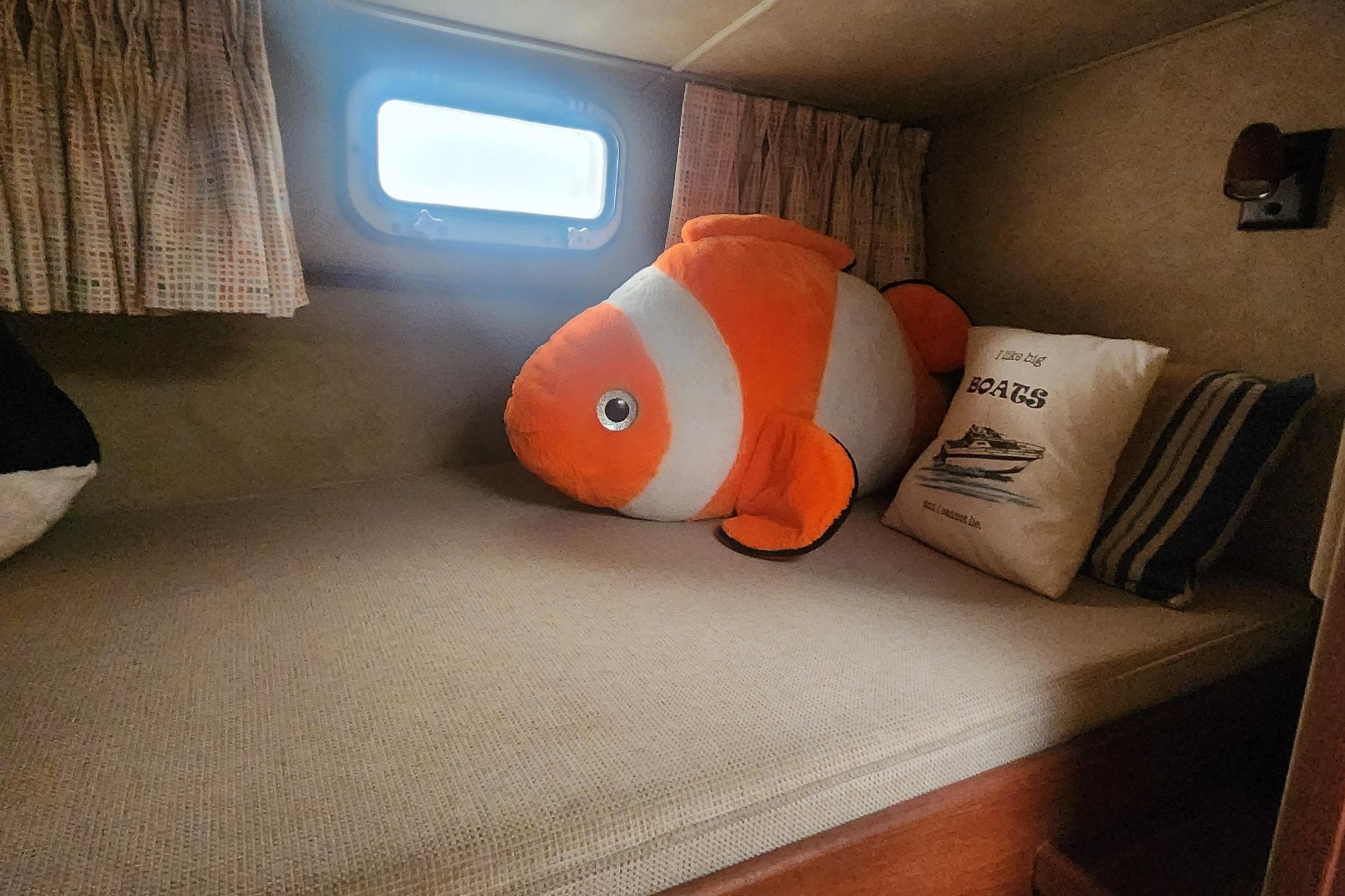 Cozy cabin interior of 1985 Bertram 33 Flybridge Cruiser with plush fish toy.