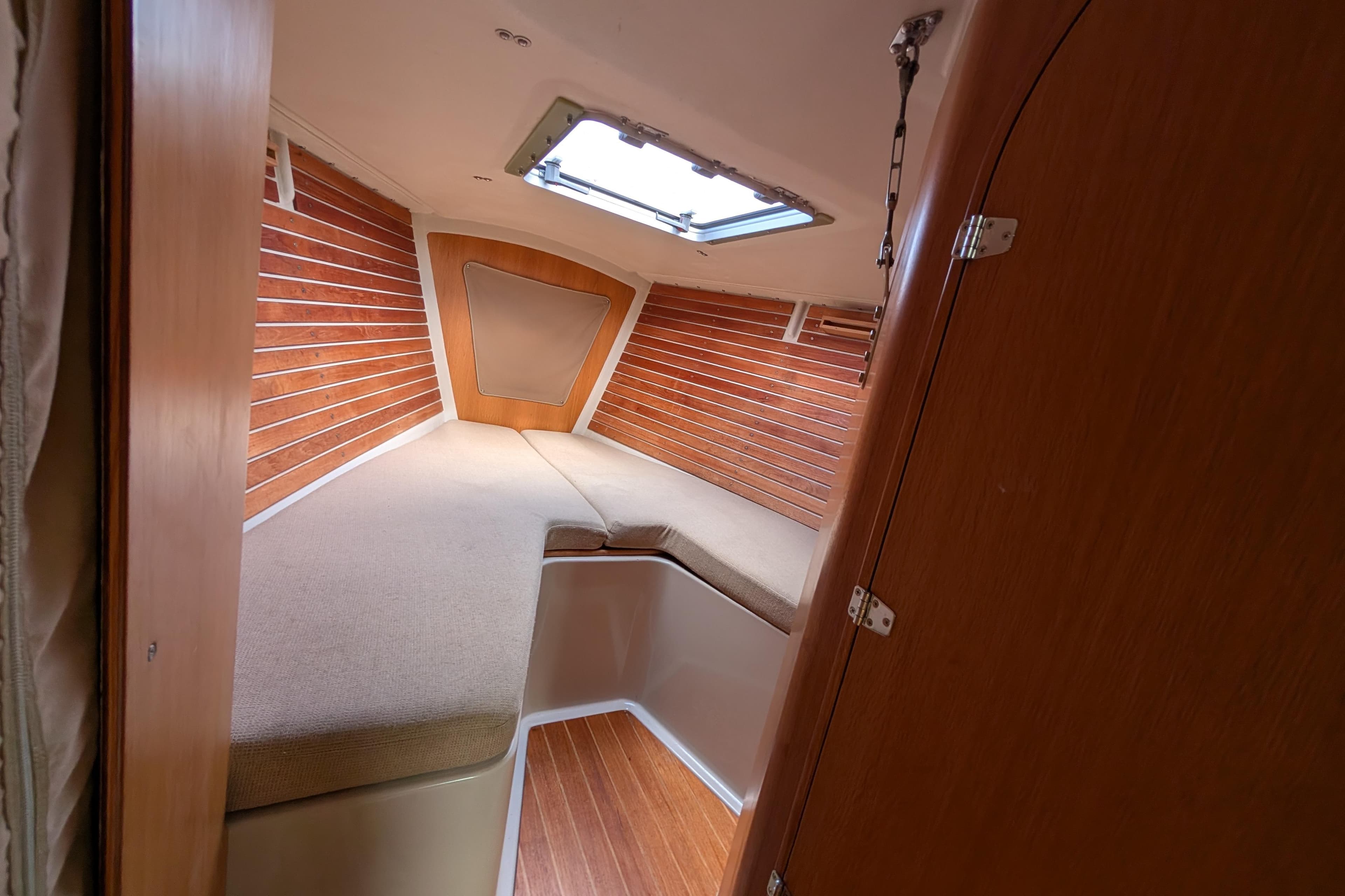 Cozy cabin interior of 1986 Express 37 sailboat with wooden paneling and skylight.
