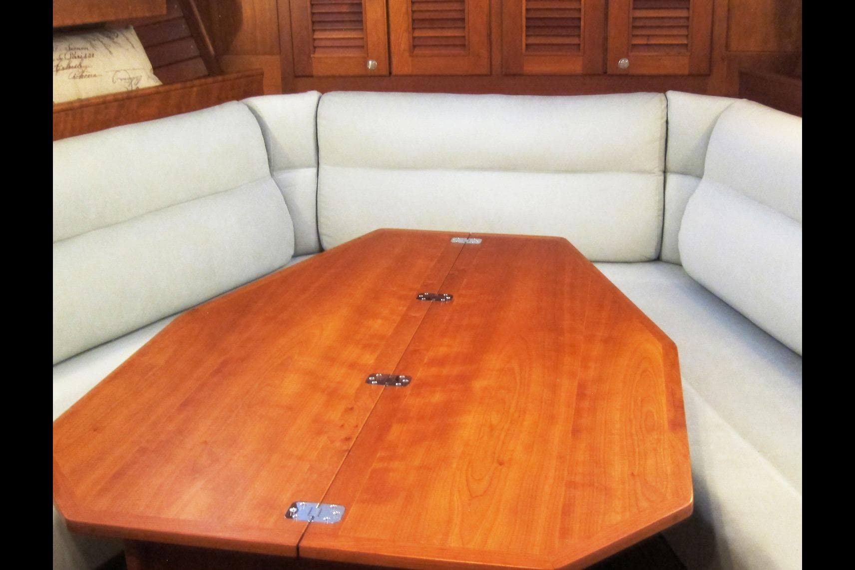 Interior of 2008 Gozzard 41B yacht with wooden table and cushioned seating.