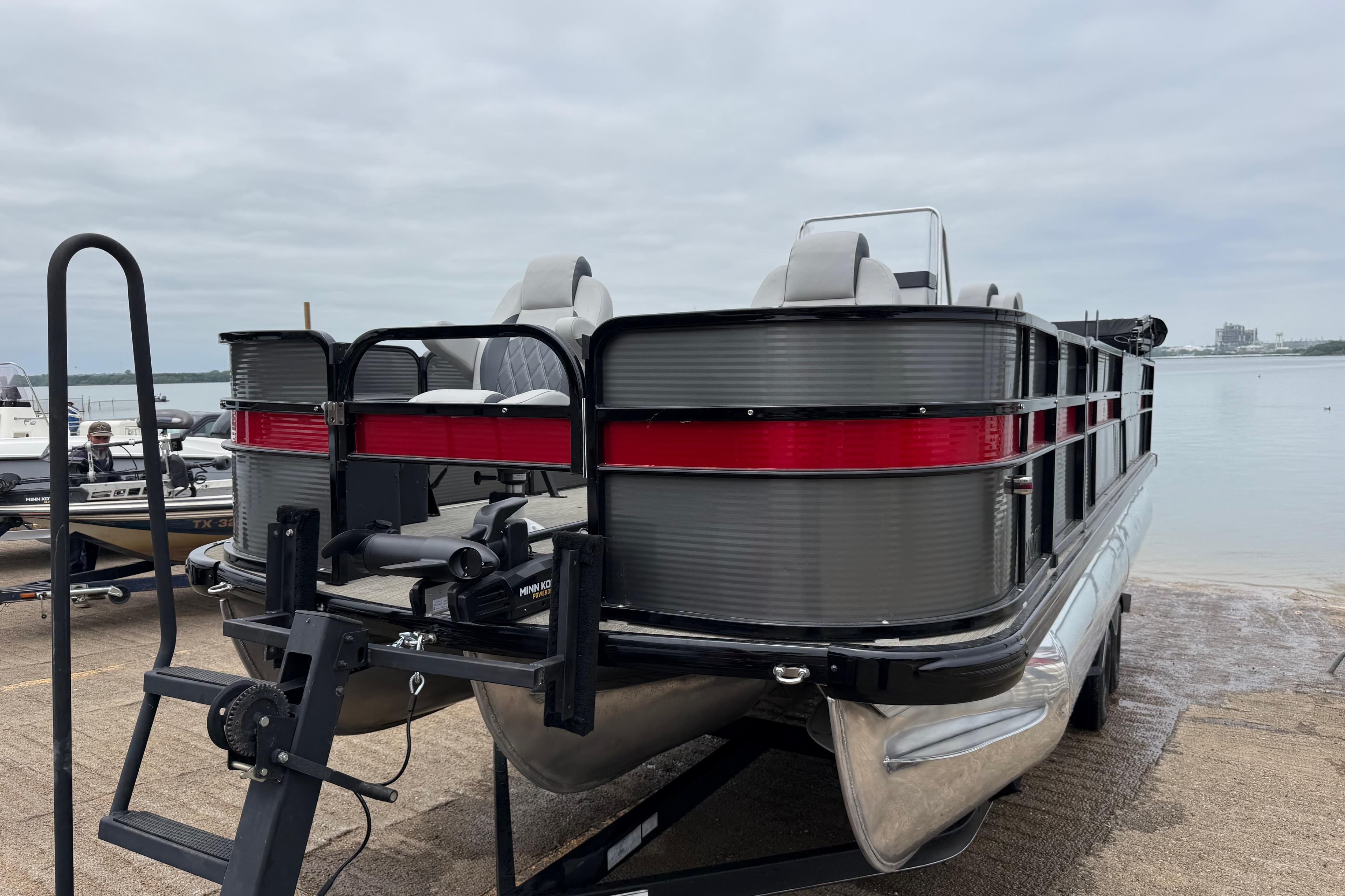 2018 Misty Harbor 210 RF pontoon boat on trailer by the water.
