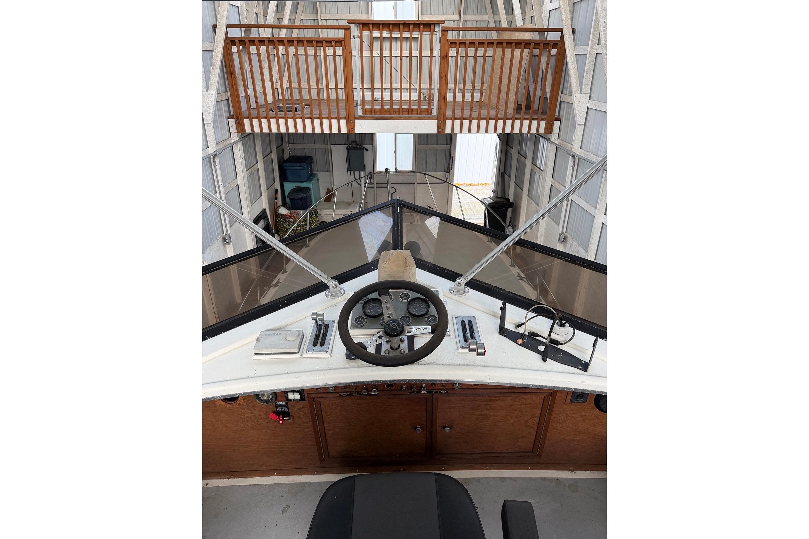 1974 Magnum Sportfisher boat helm with steering wheel and controls in a docked setting.