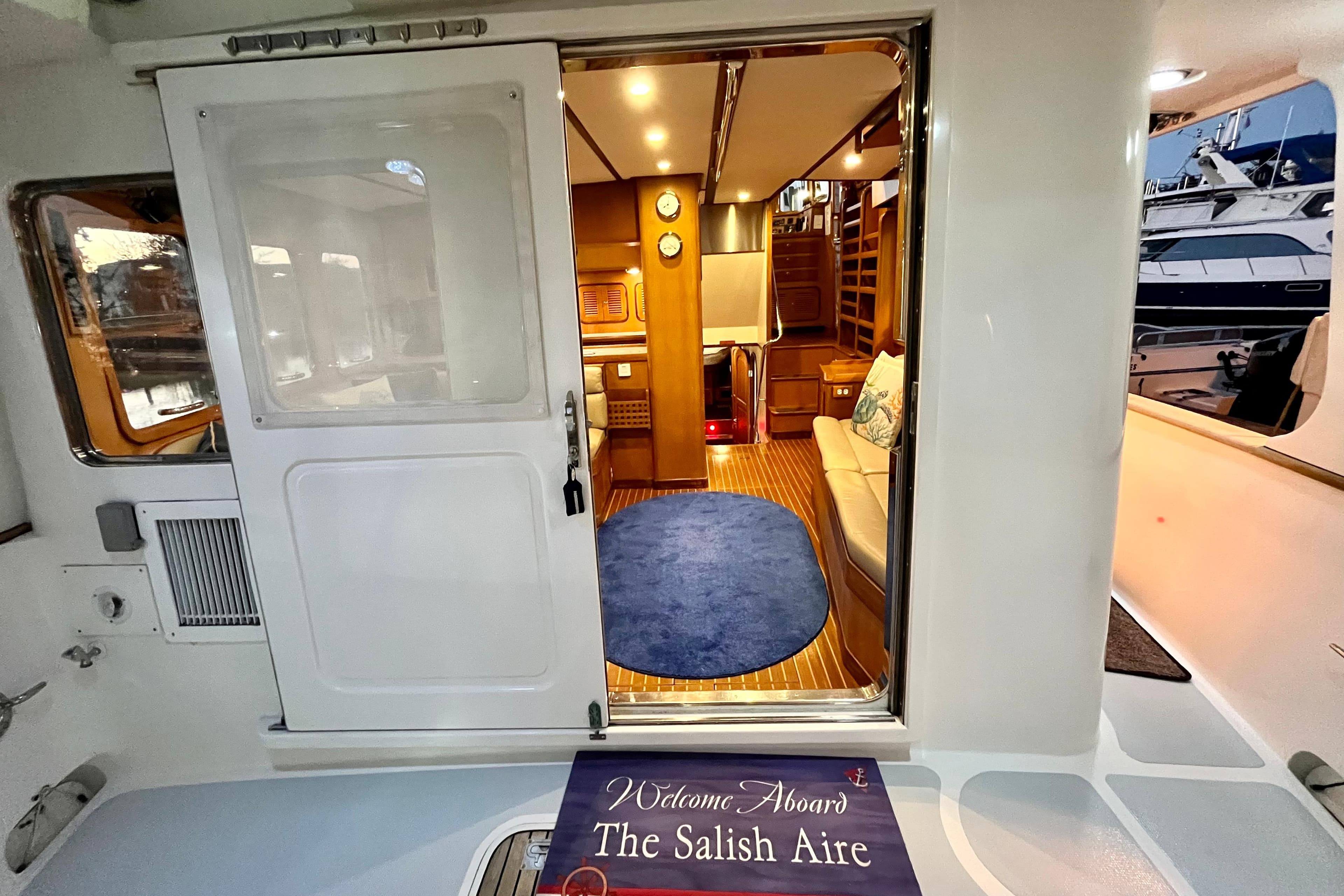 Interior view of 1996 Nordhavn 46 yacht, featuring cozy seating and elegant wood finishes.
