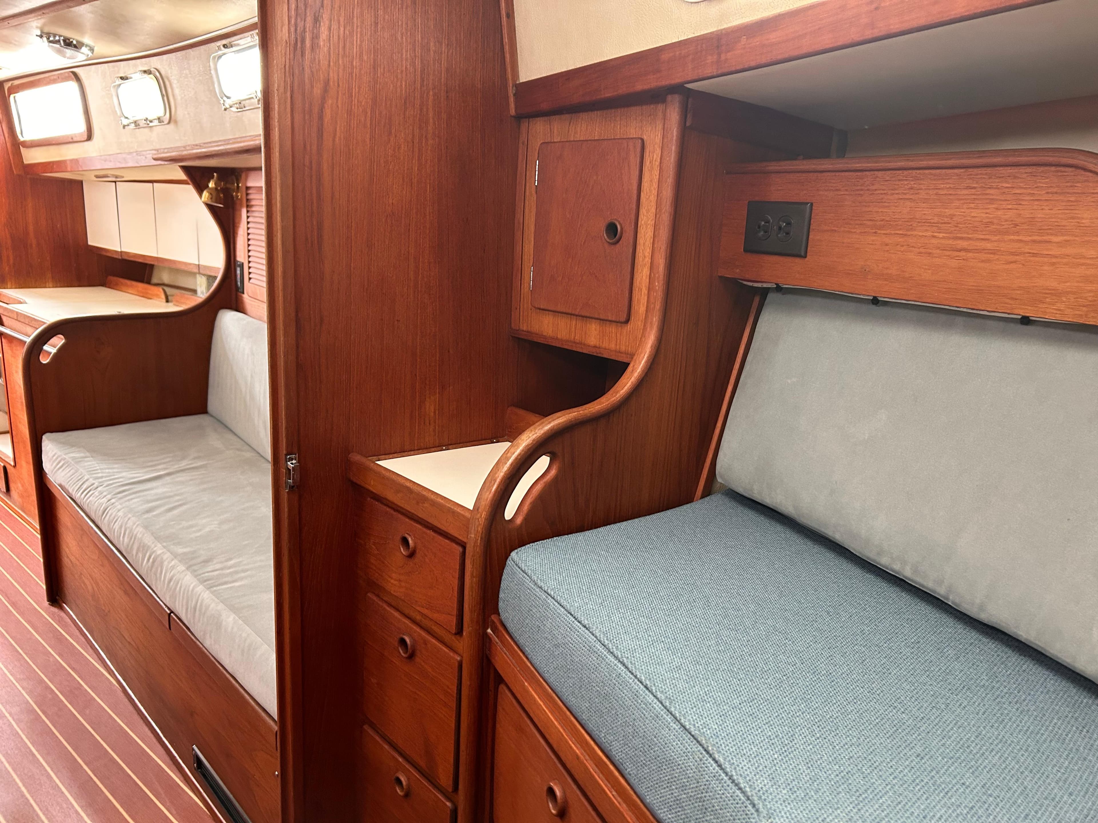 1983 Sabre 38 yacht interior with wooden cabinetry and cushioned seating.