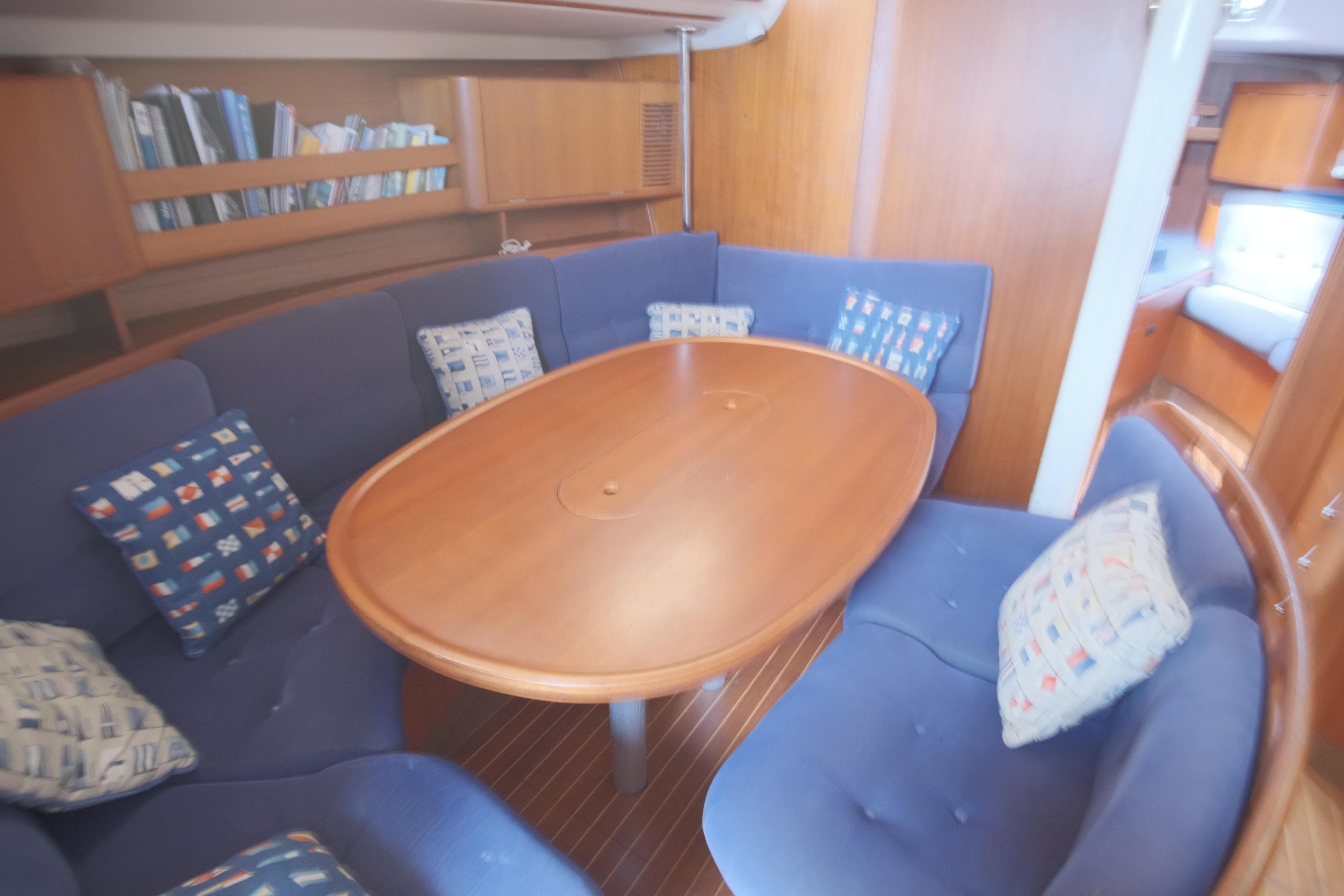 Interior of 2000 X-Yachts 442 MK II with blue seating and wooden table.