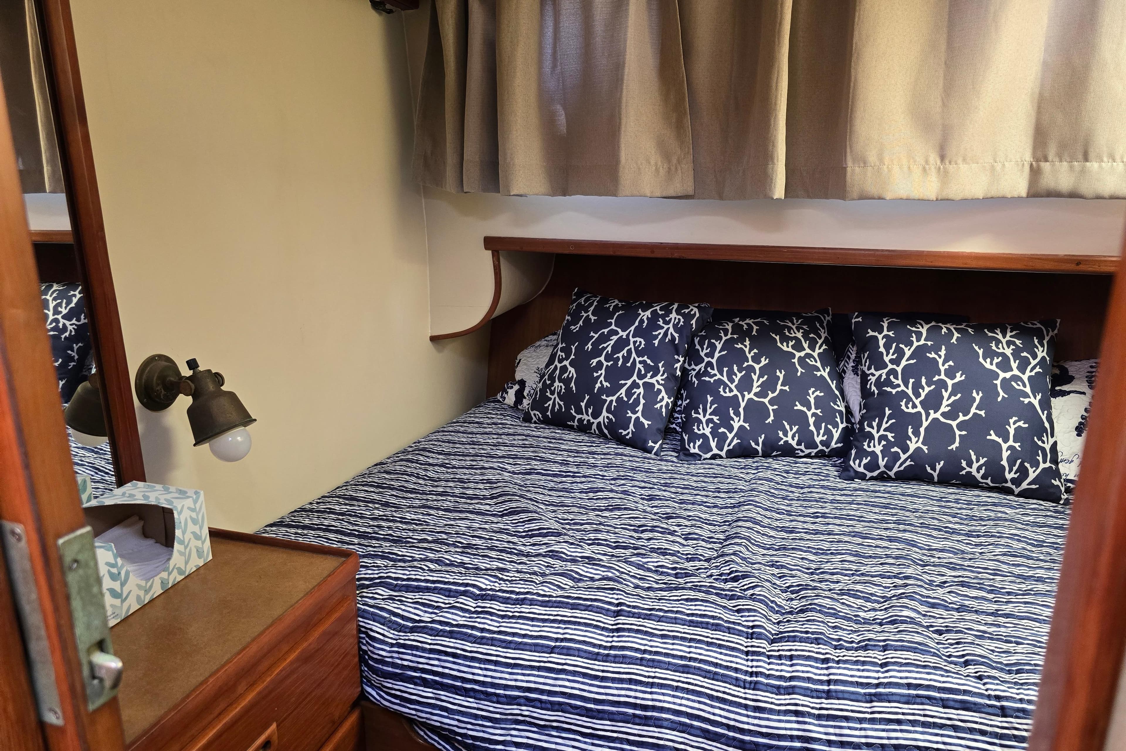 Cozy cabin bedroom in 1989 Offshore Yachts 48 Sedan with nautical-themed bedding.
