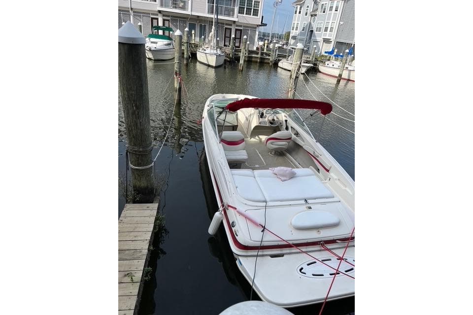 2004 Maxum 2200 SR3 boat docked in a marina with red canopy.