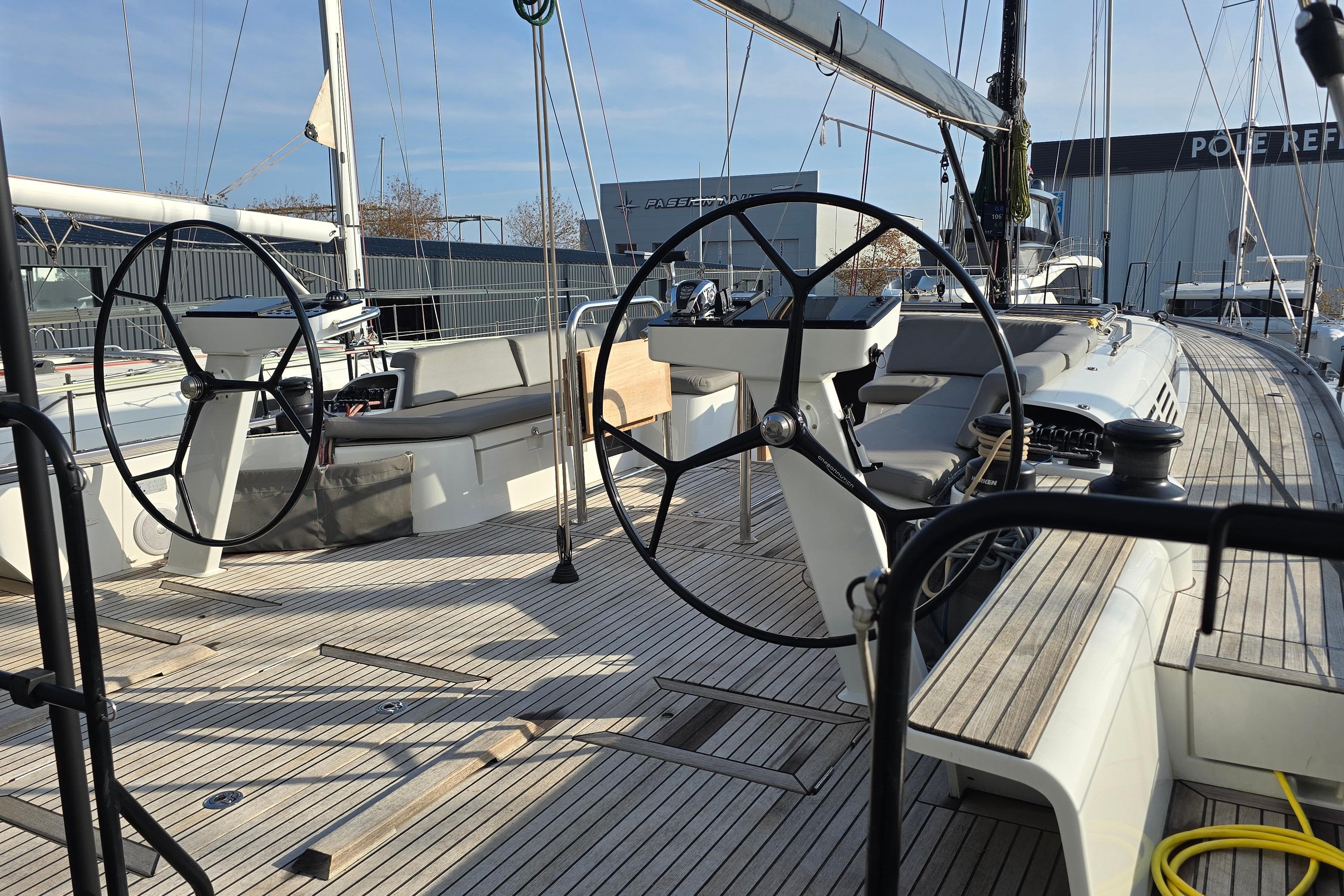 2022 Beneteau First 53 sailboat deck with dual steering wheels and sleek design.