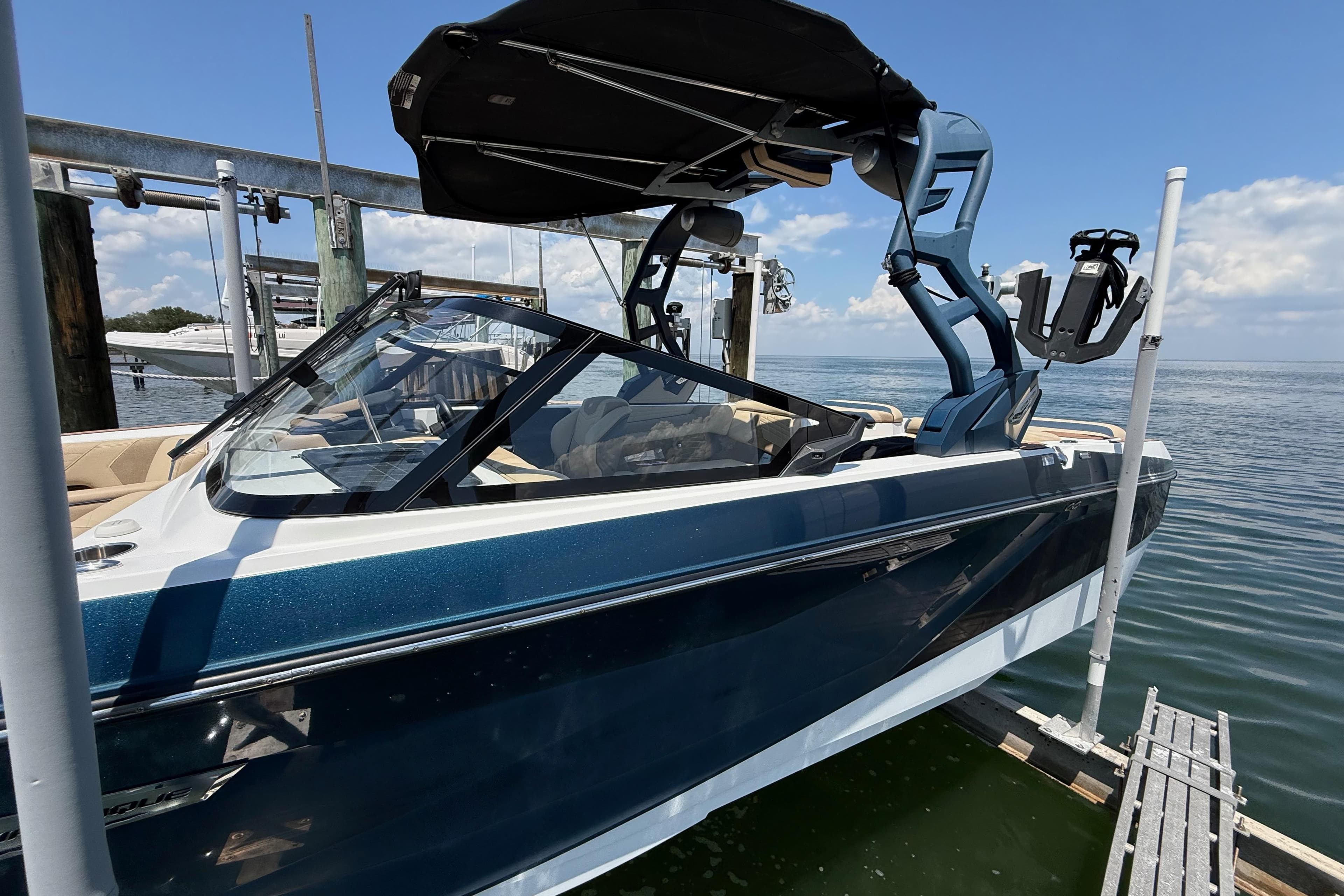 2021 Nautique Super Air Nautique G21 boat docked, featuring sleek design and modern wakeboard tower.