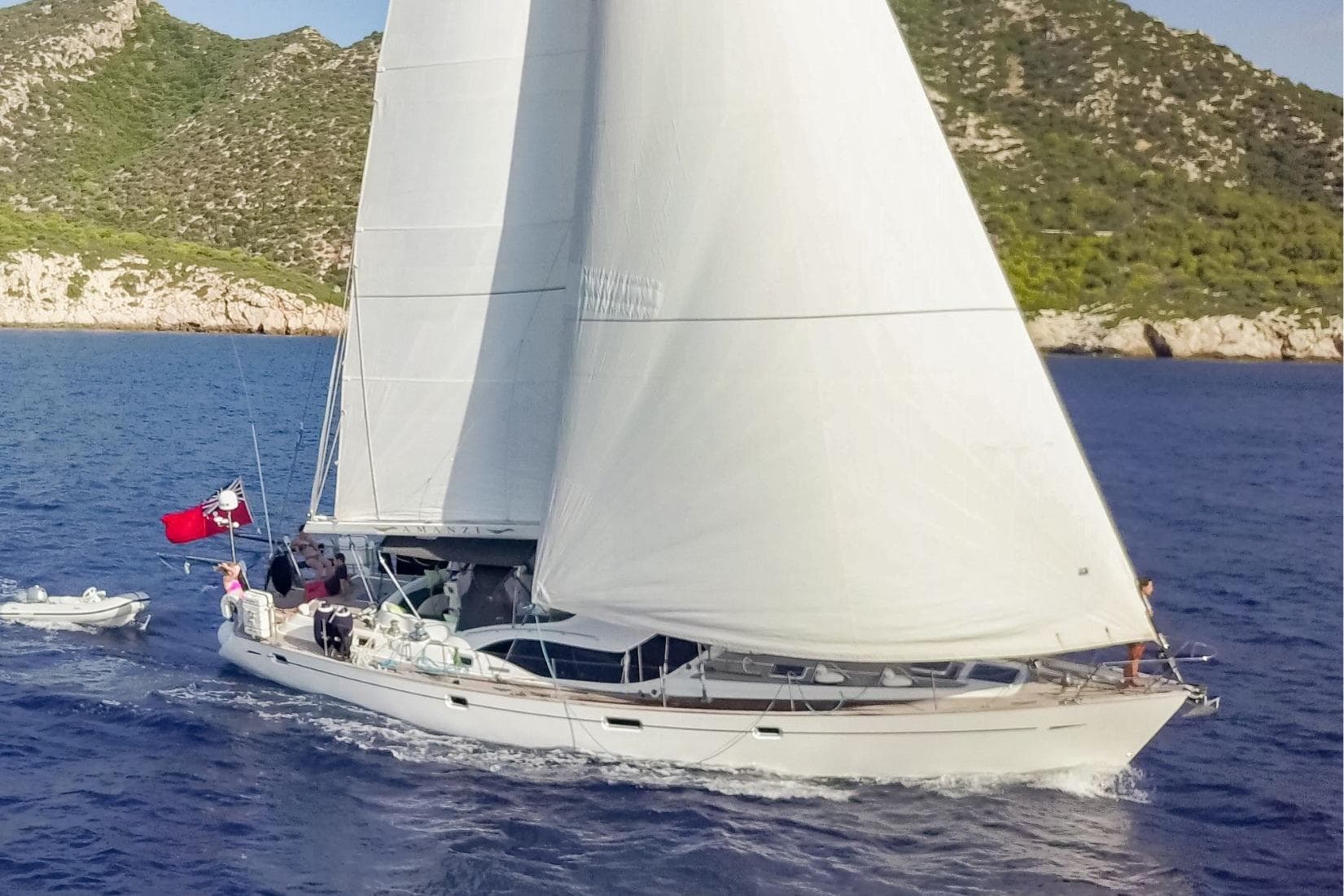 Sailing yacht Oyster 56 (2007) cruising near rocky coastline.