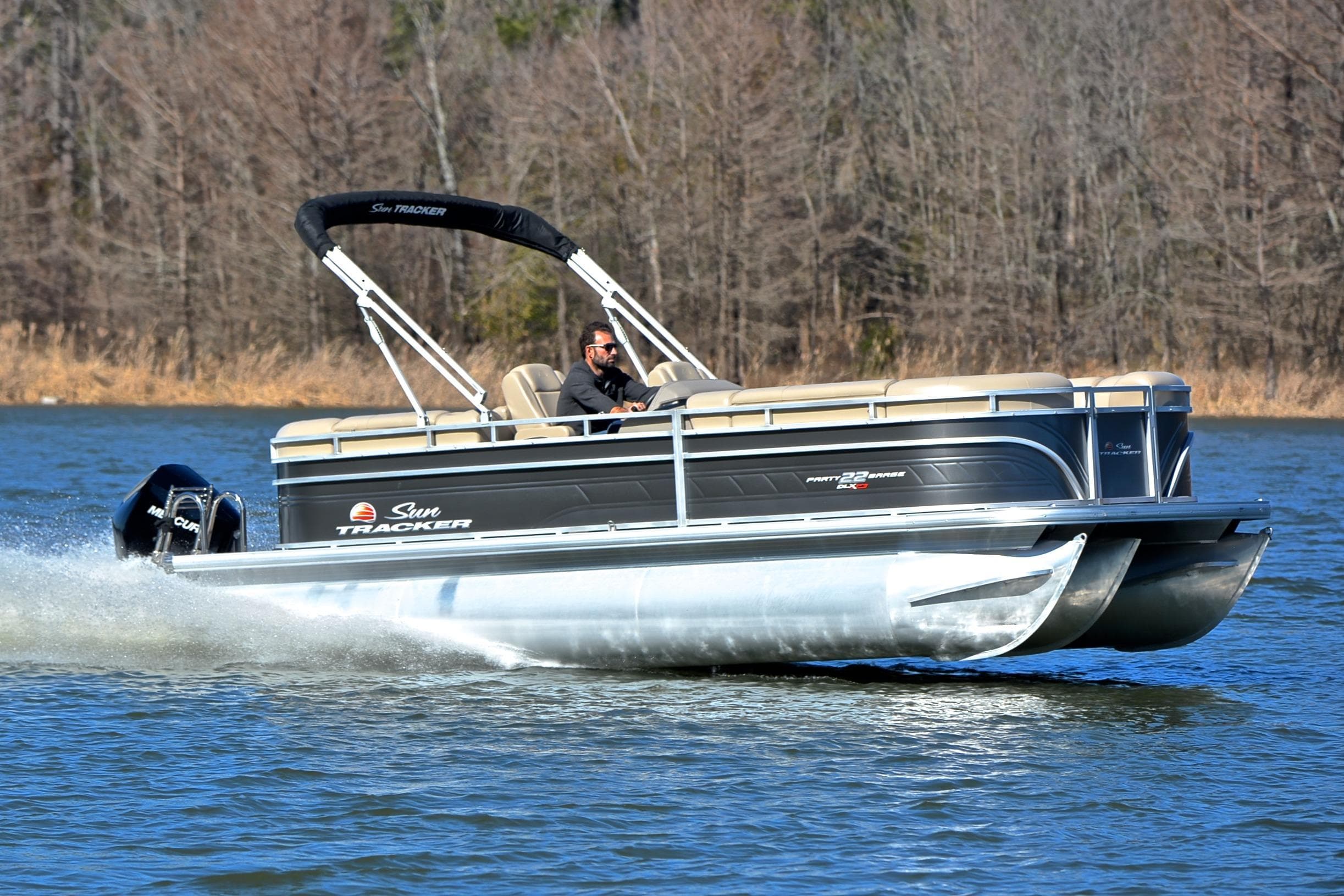 2024 Sun Tracker Party Barge 22 XP3 pontoon boat cruising on a lake.