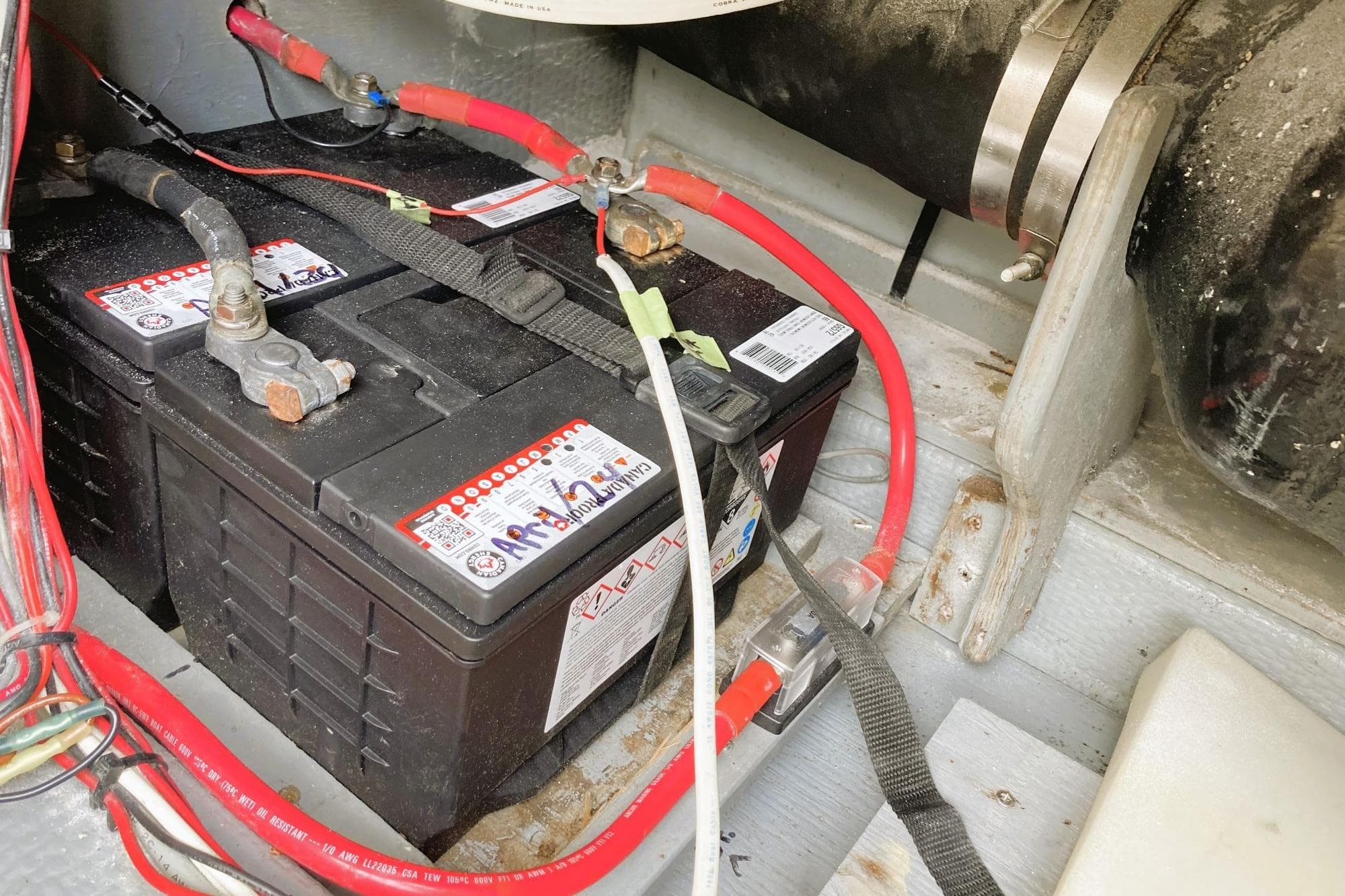 Battery compartment of 1980 Tollycraft 34 Sedan with connected cables and wiring.