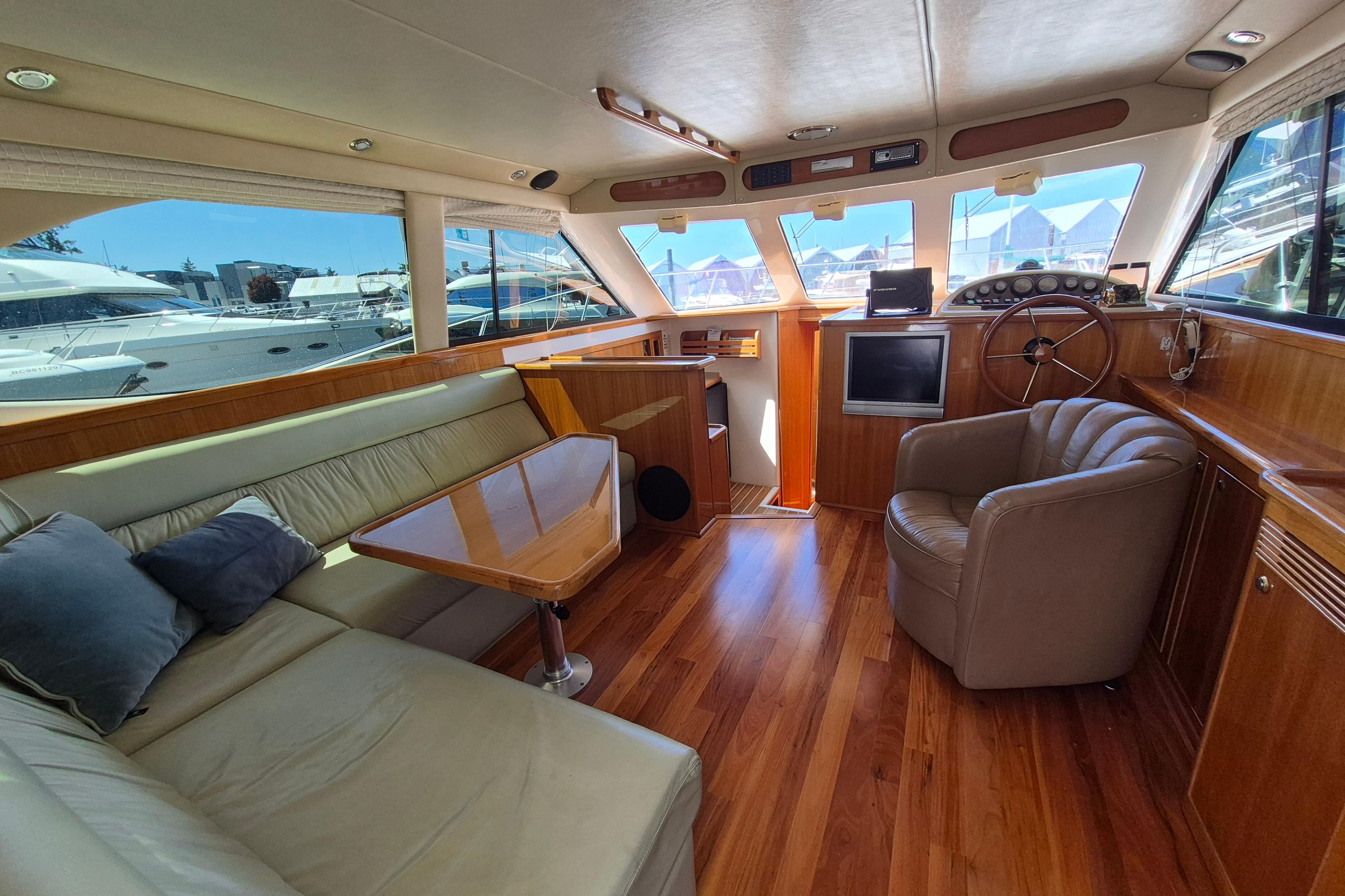 Luxurious 2001 Riviera 40 Flybridge yacht interior with leather seating and wooden accents.