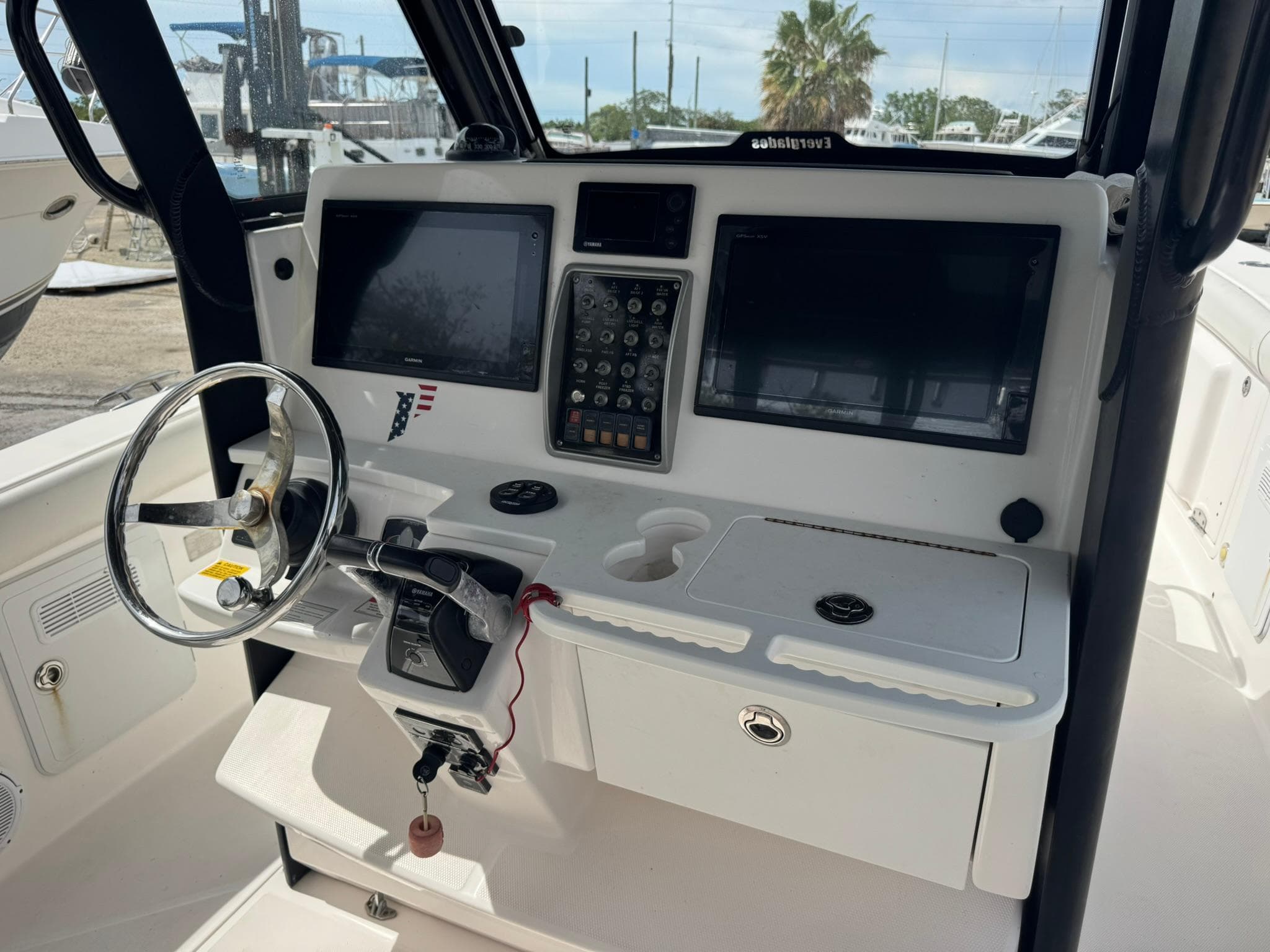 2016 Everglades 355 Tournament boat dashboard with steering wheel and navigation screens.