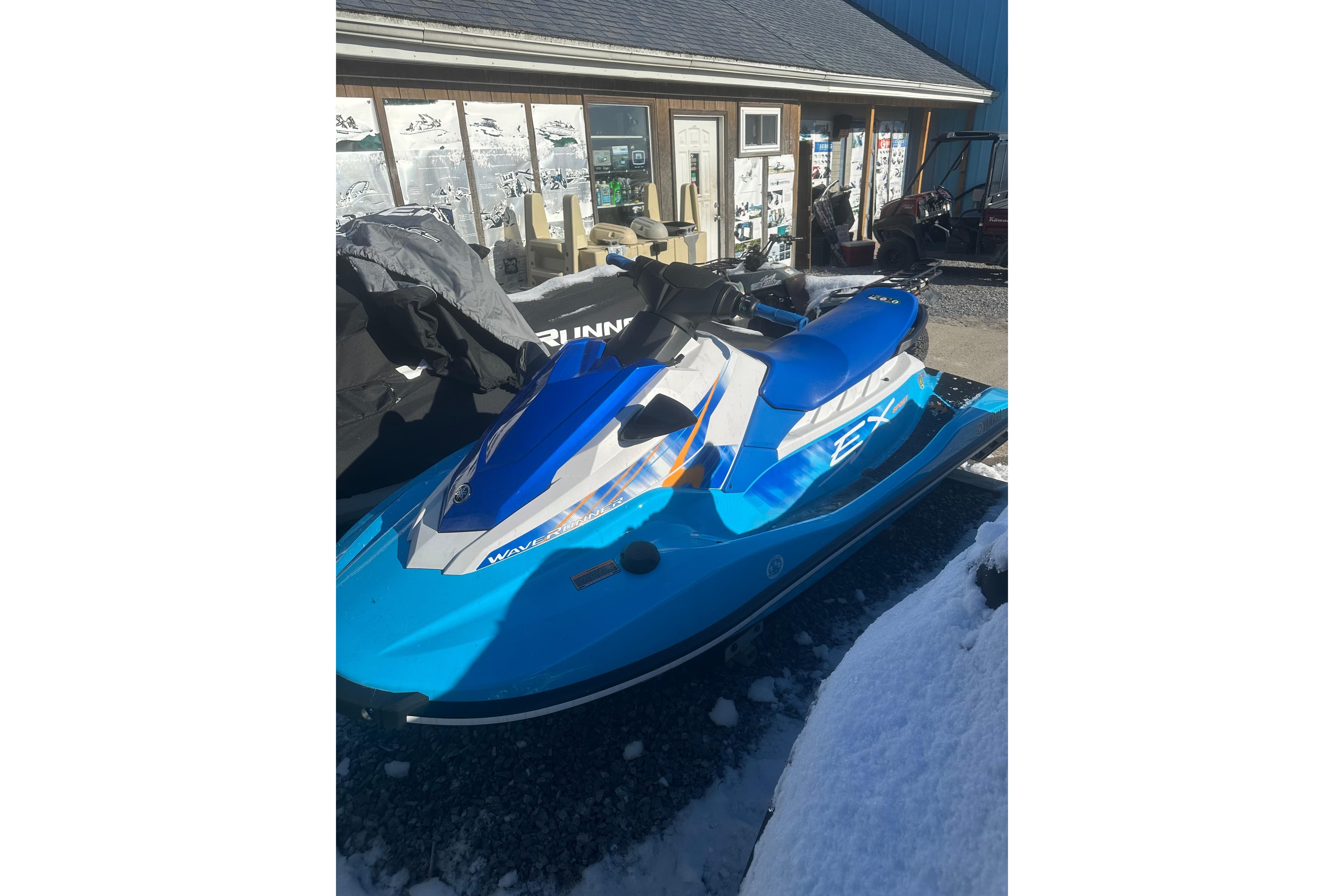 2024 Yamaha WaveRunner EX Sport in blue, parked outdoors on a snowy day.