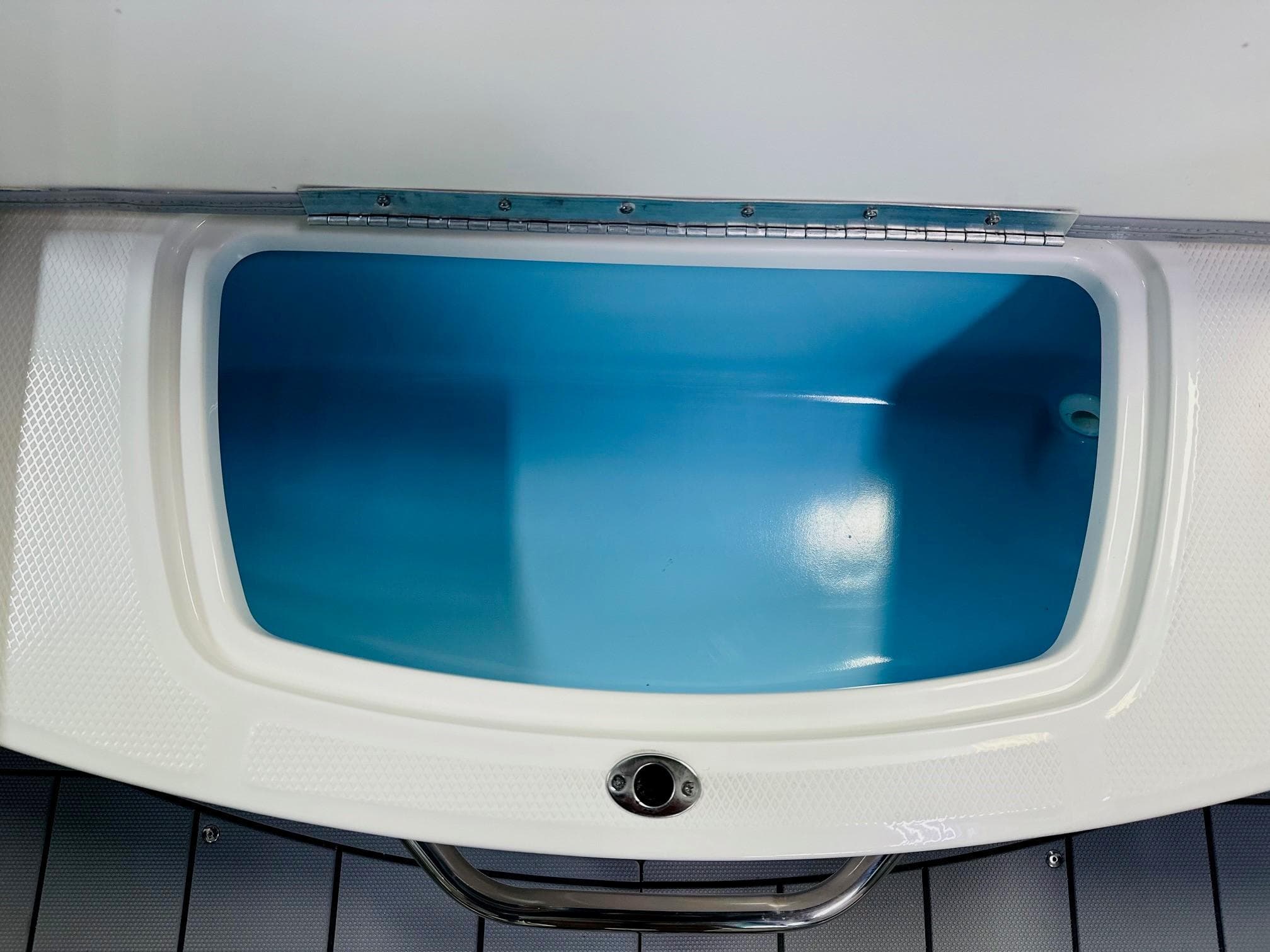2025 Chaparral 21 SSi OB boat storage compartment with blue interior.