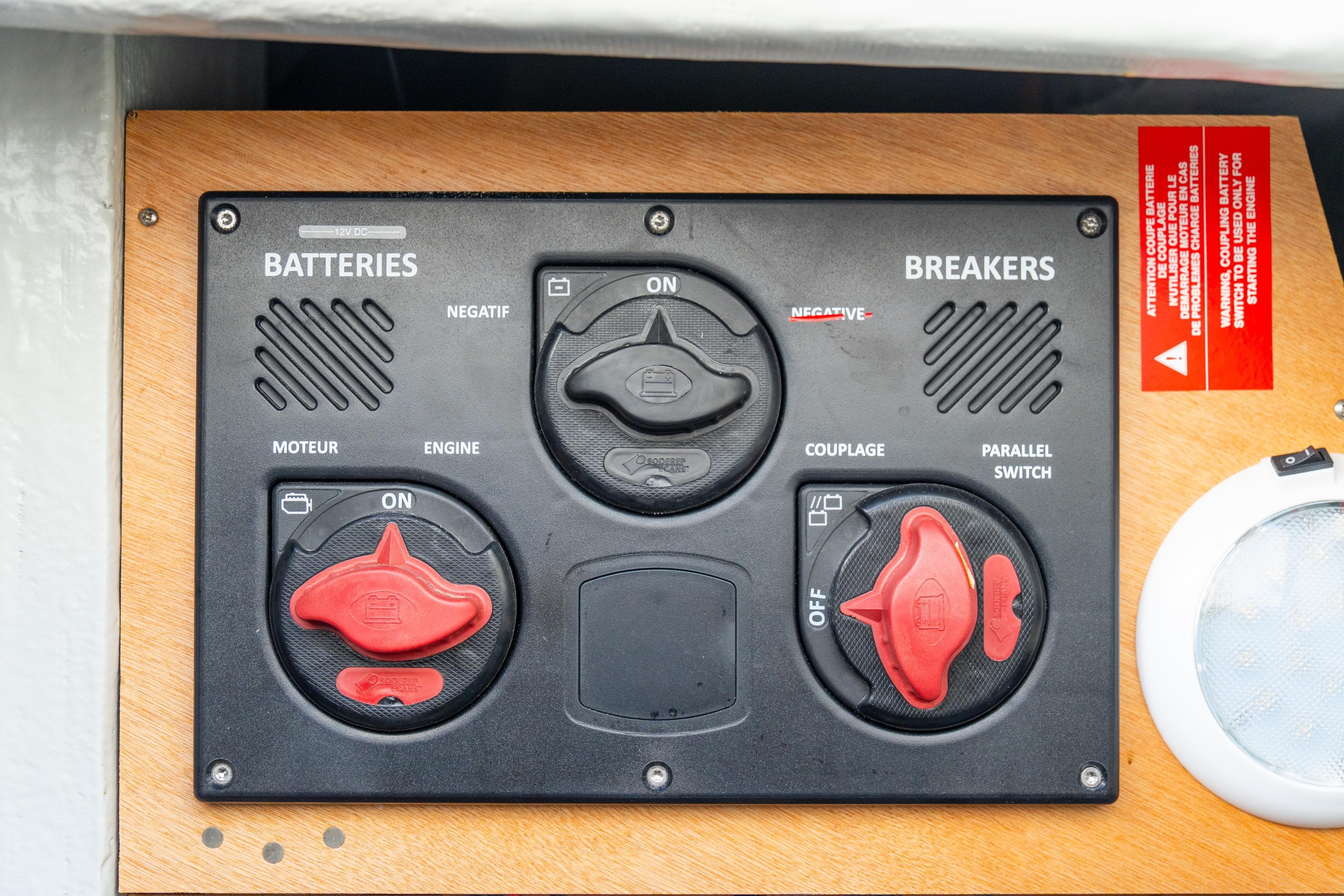 Battery and breaker panel on 2023 Lagoon 46 yacht, featuring switches and labels.
