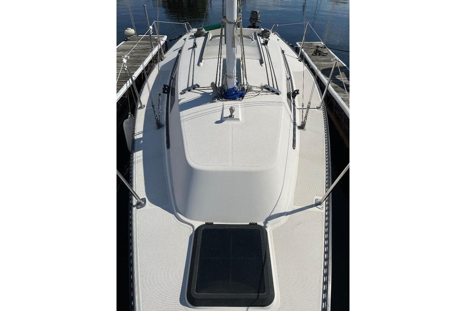 1985 S2 K sailboat deck view, docked, showcasing rigging and hatch.