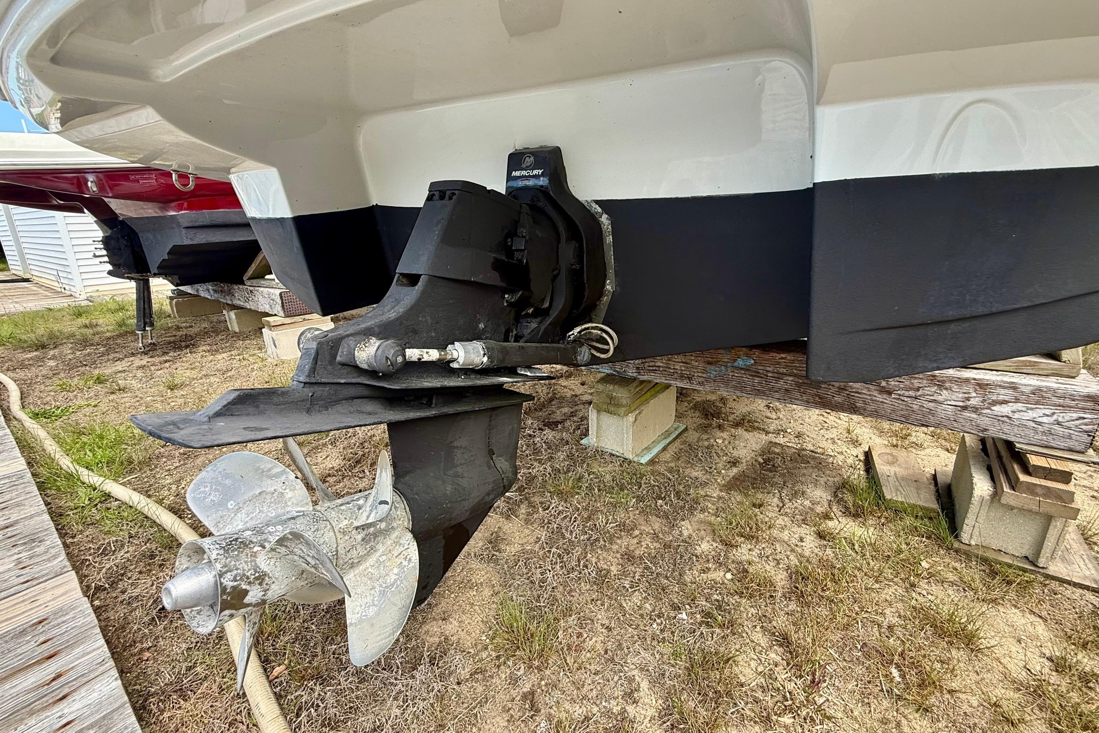 2020 Crownline Eclipse E235 boat stern with Mercury outdrive on wooden supports.