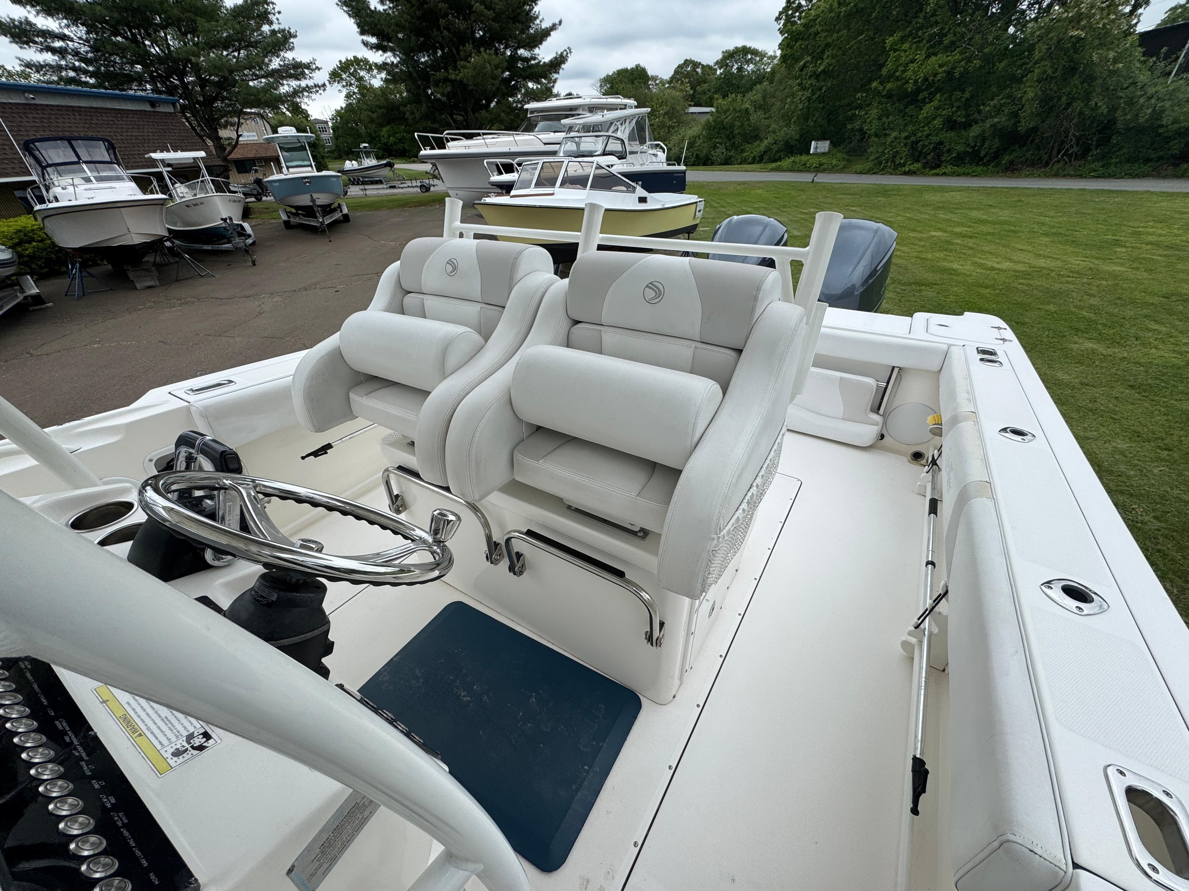 2013 Edgewater 318CC boat interior with dual white seats and steering wheel.
