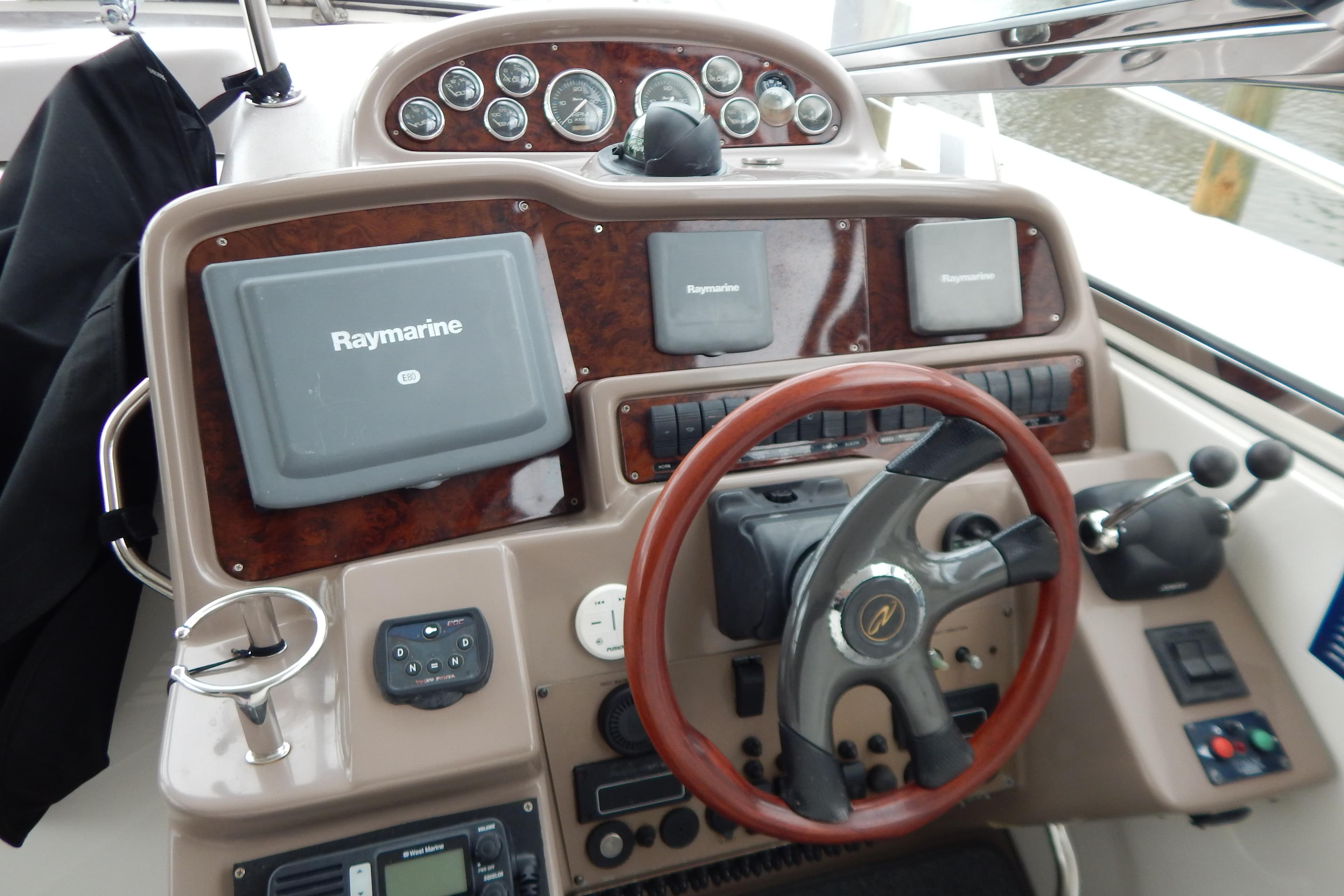 2004 Regal Commodore 4260 helm with Raymarine navigation system and wooden steering wheel.