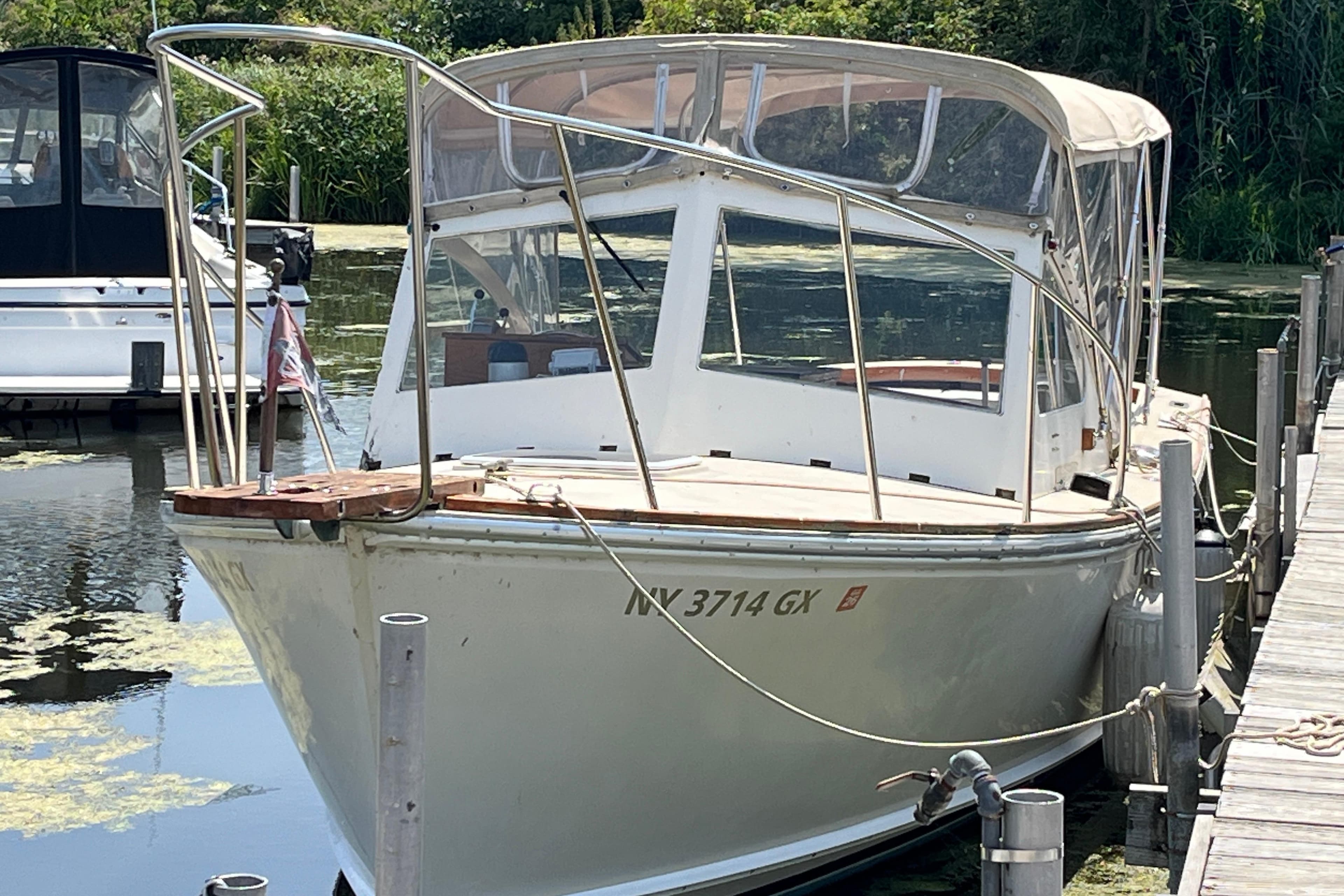 1981 Dyer 29 Flush Deck/Bass Boat docked in a serene marina setting.