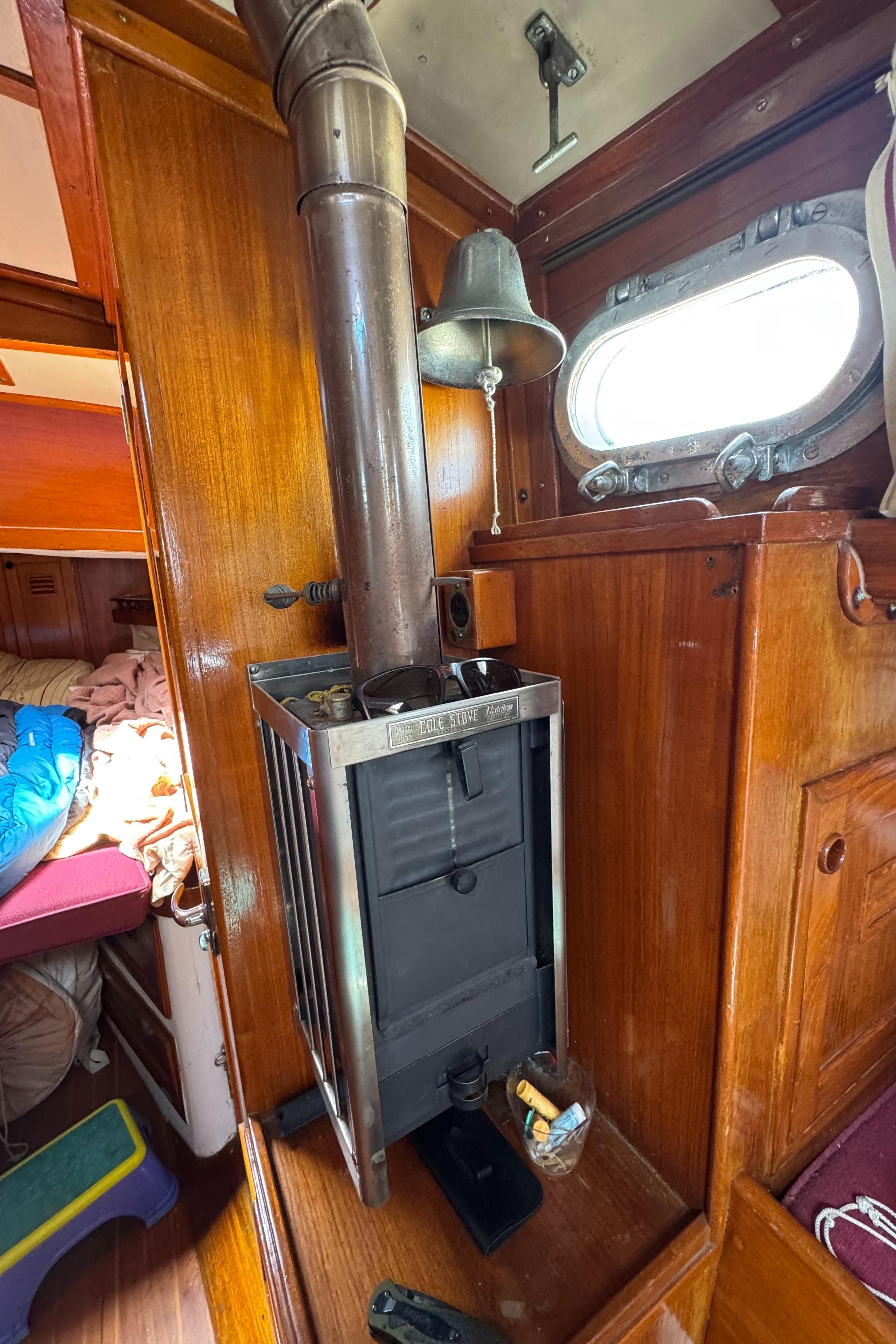 1979 Cheoy Lee Bill Luders Clipper Ketch interior with wood stove and porthole.