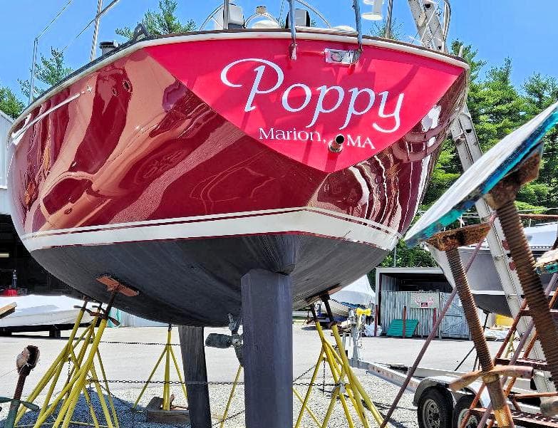 Red C&C 38 sailboat named "Poppy" in a boatyard, Marion, MA, 1976 model.