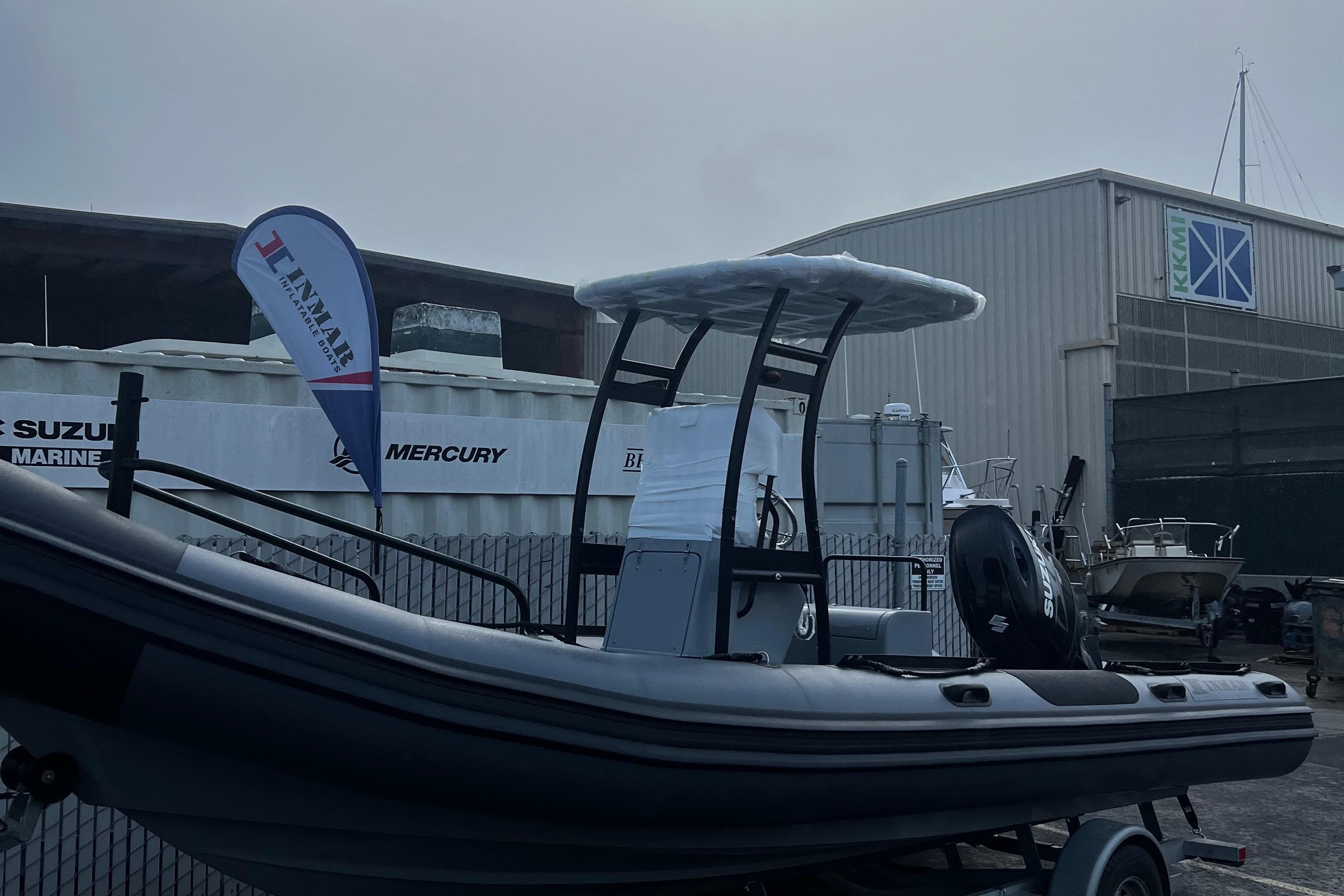 2024 Inmar 670 Demo Boat displayed outdoors with a canopy and trailer.