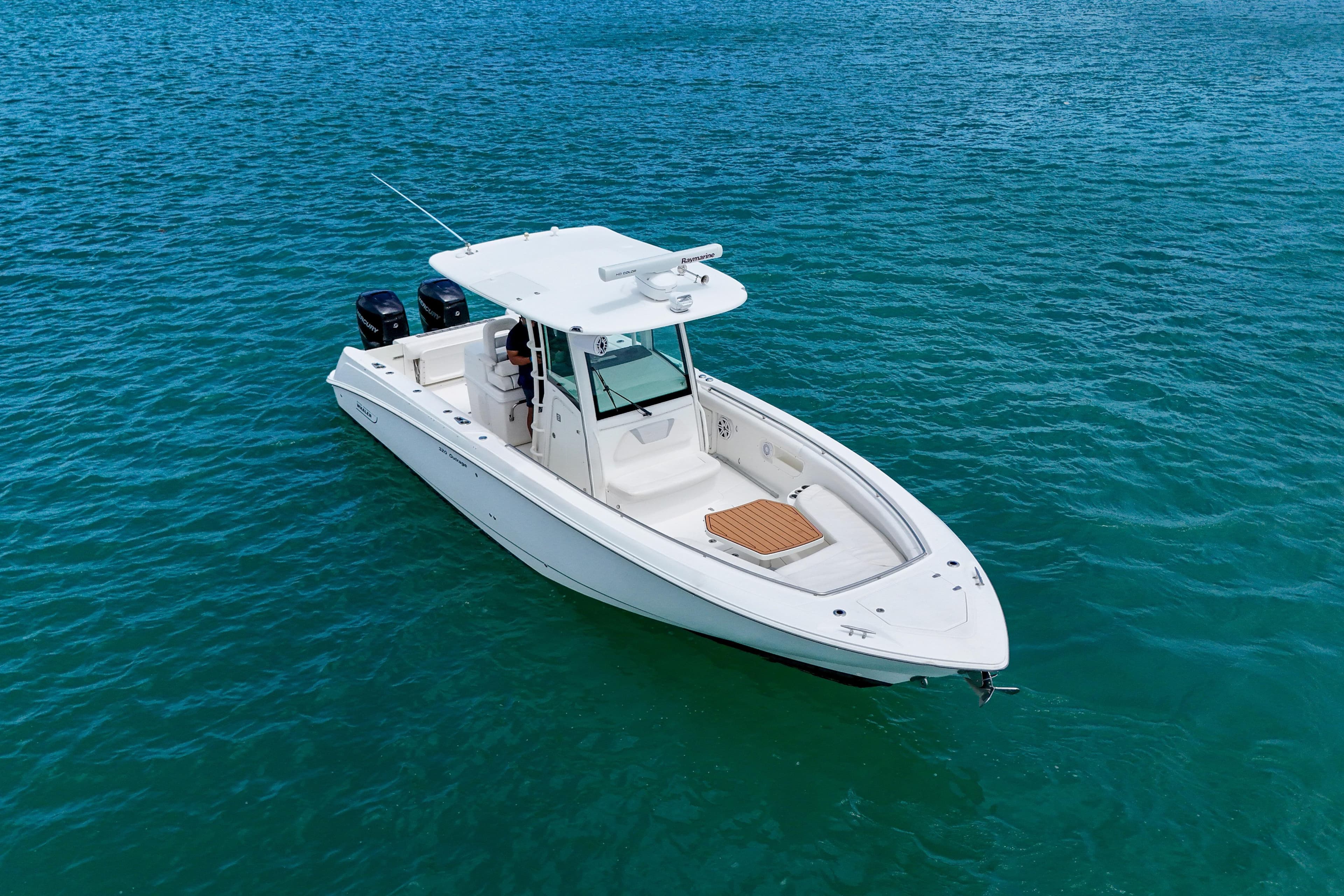 2013 Boston Whaler 320 Outrage boat on clear blue water, showcasing sleek design.