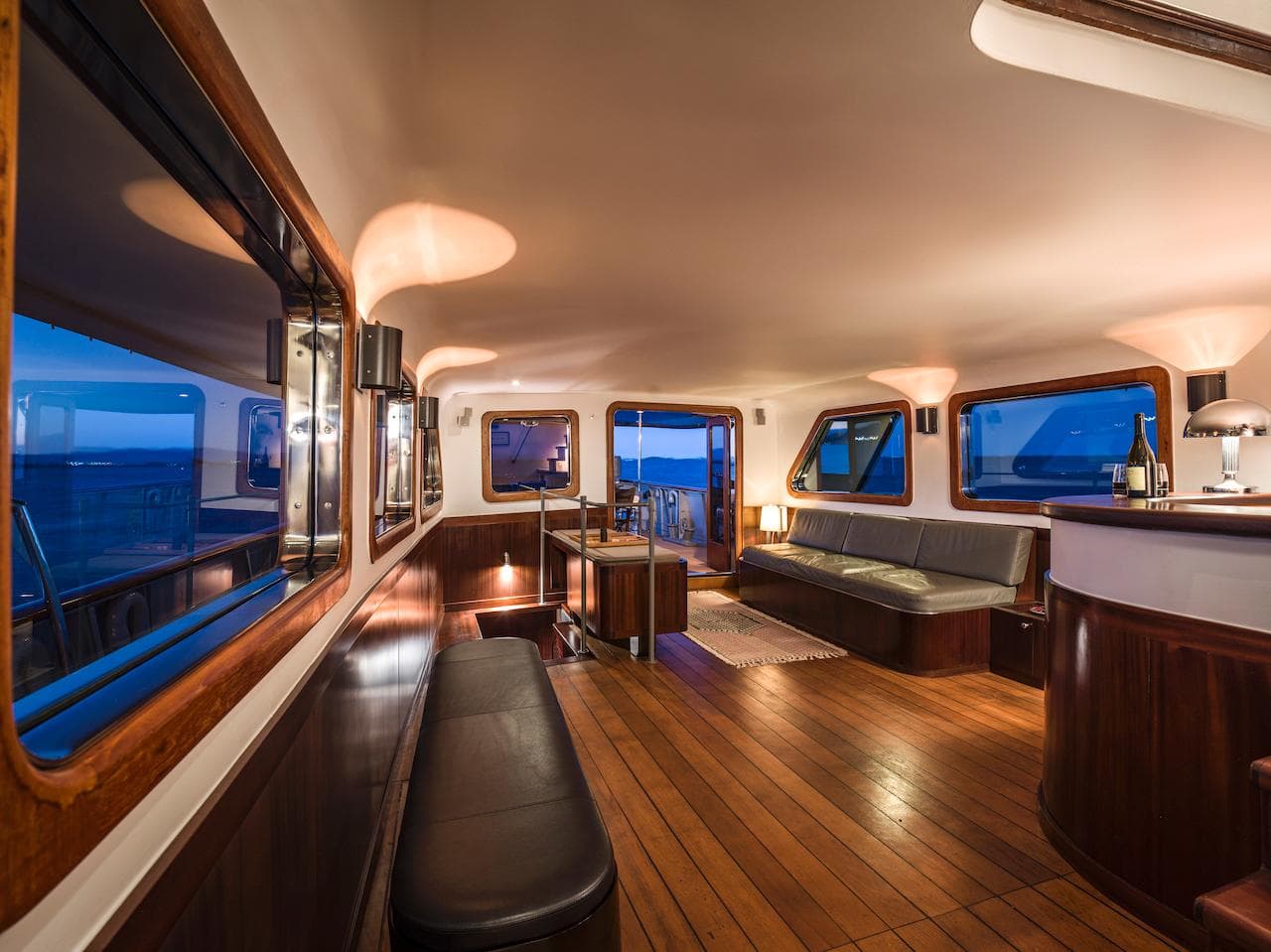 Interior of a 1962 Laurent Giles yacht with wooden floors and elegant lighting.