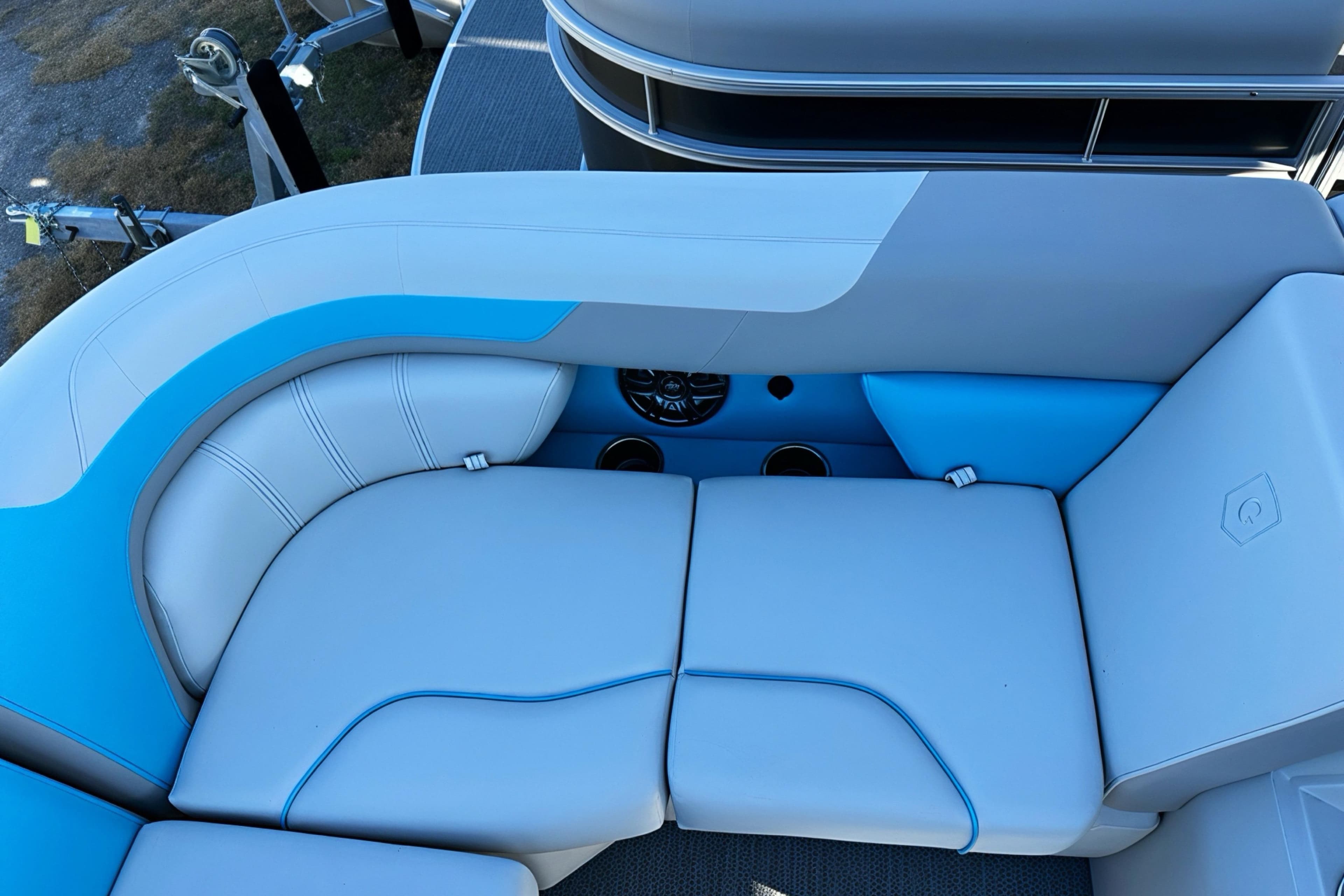 Luxurious seating on 2026 Sweetwater 2286 QS pontoon boat, featuring blue and white upholstery.