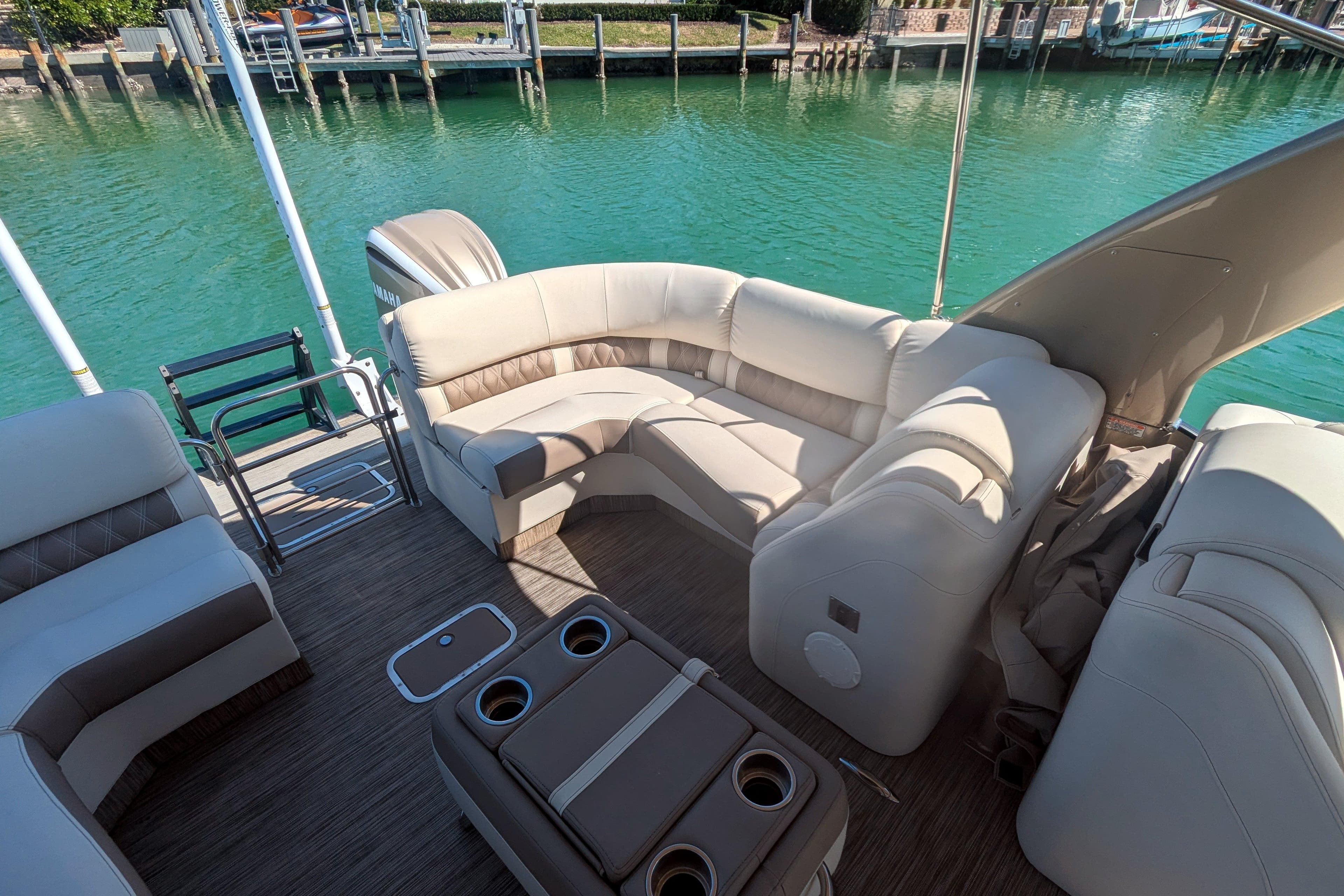 Luxurious 2022 Bennington QXFBAX2 pontoon boat interior with plush seating and cup holders.
