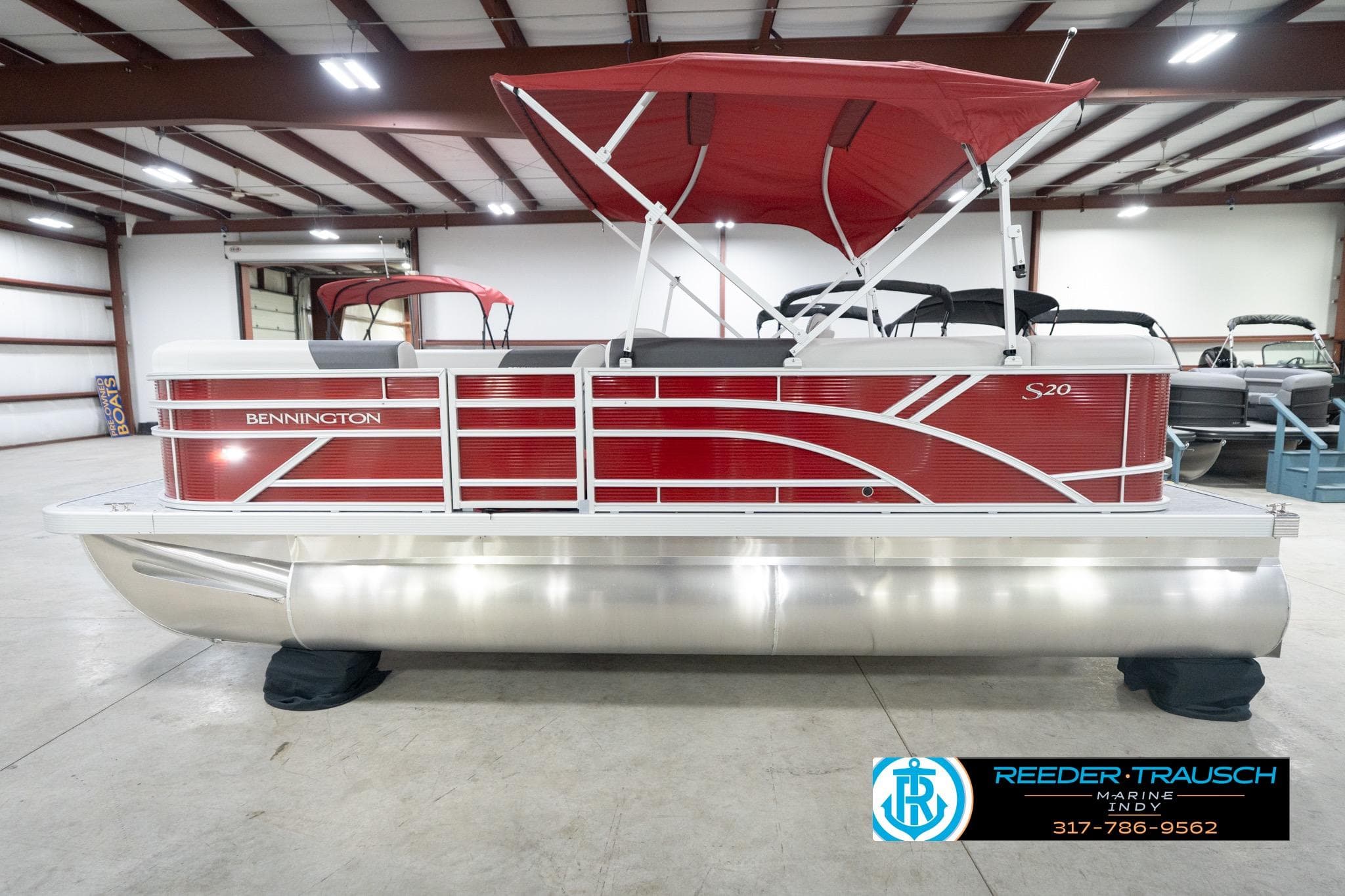 2026 Bennington 20 SL pontoon boat with red exterior and canopy in showroom.