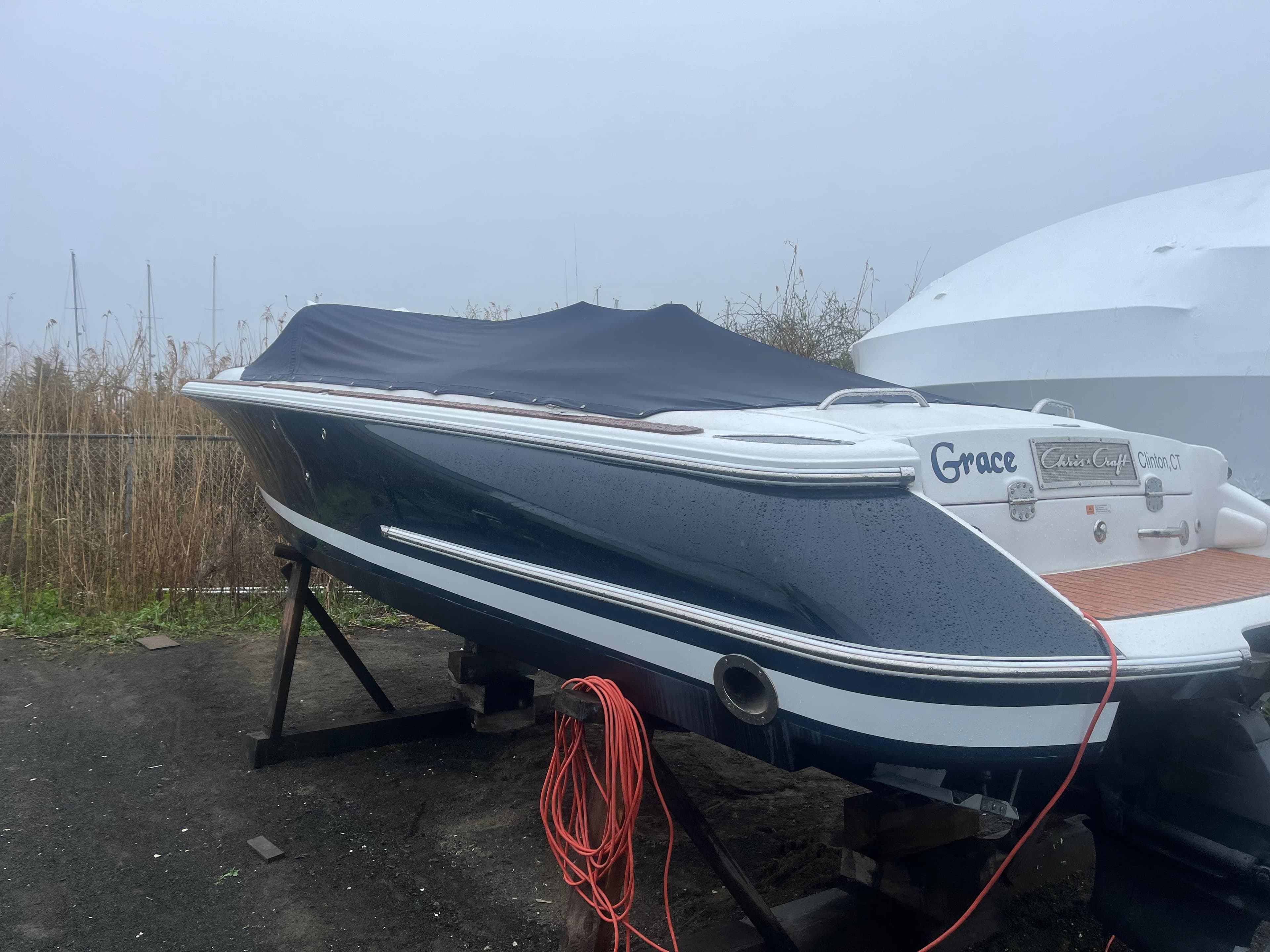 2004 Chris-Craft Corsair 25 boat on stand, covered, with visible wiring.