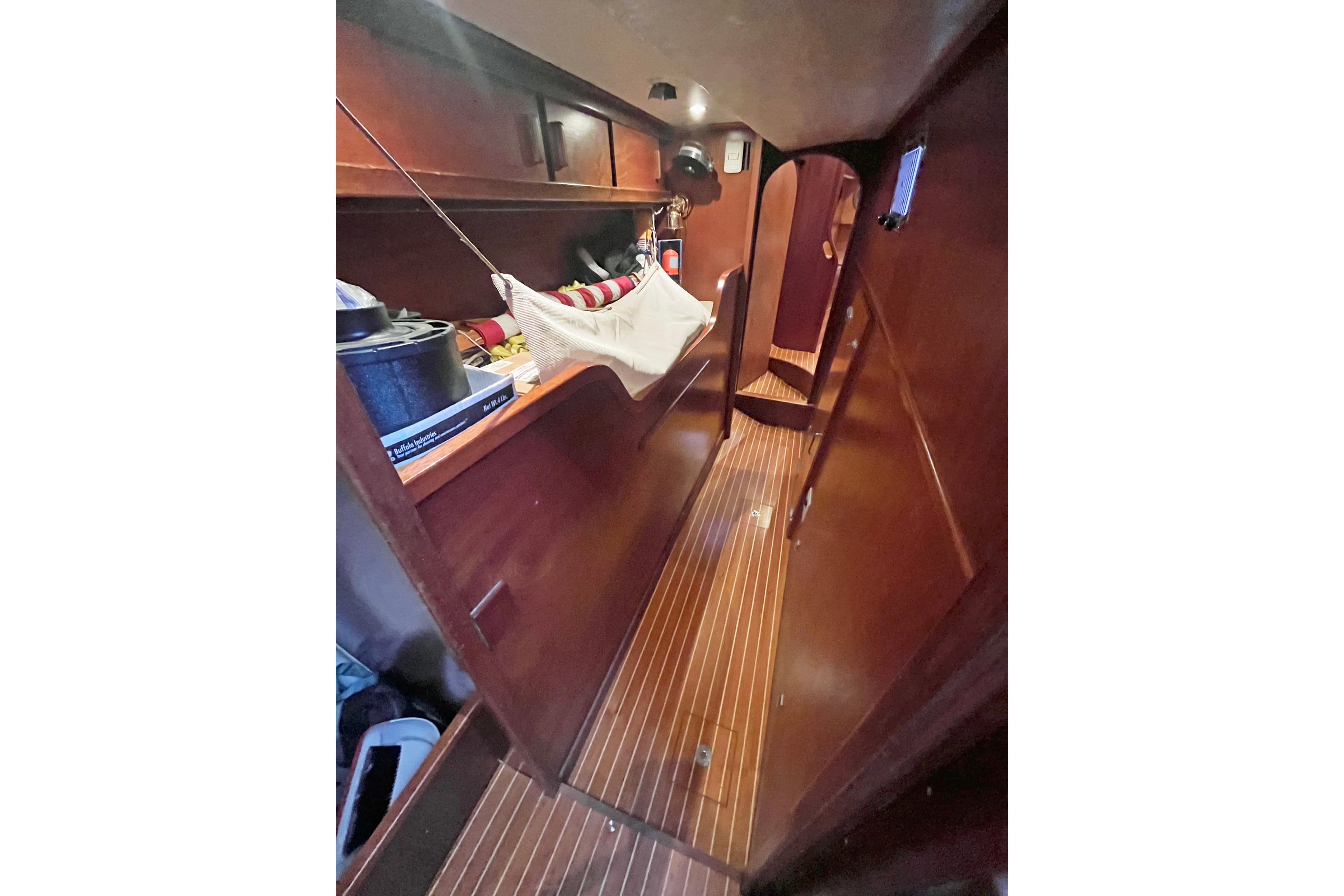 Interior of a 1979 Amel Mango sailboat with wooden flooring and storage.