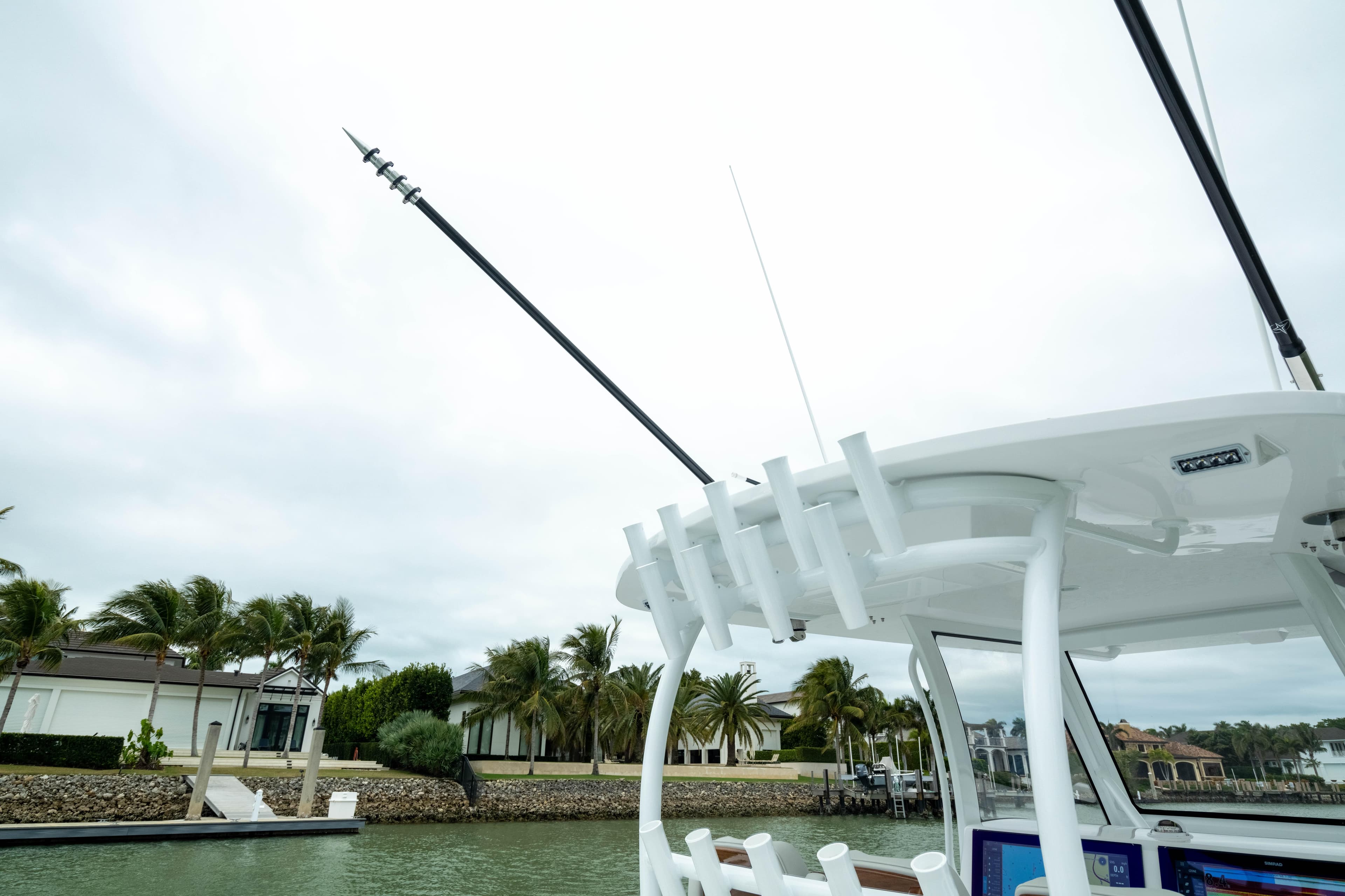 2025 Front Runner 37 Catamaran docked, featuring fishing rod holders and tropical backdrop.