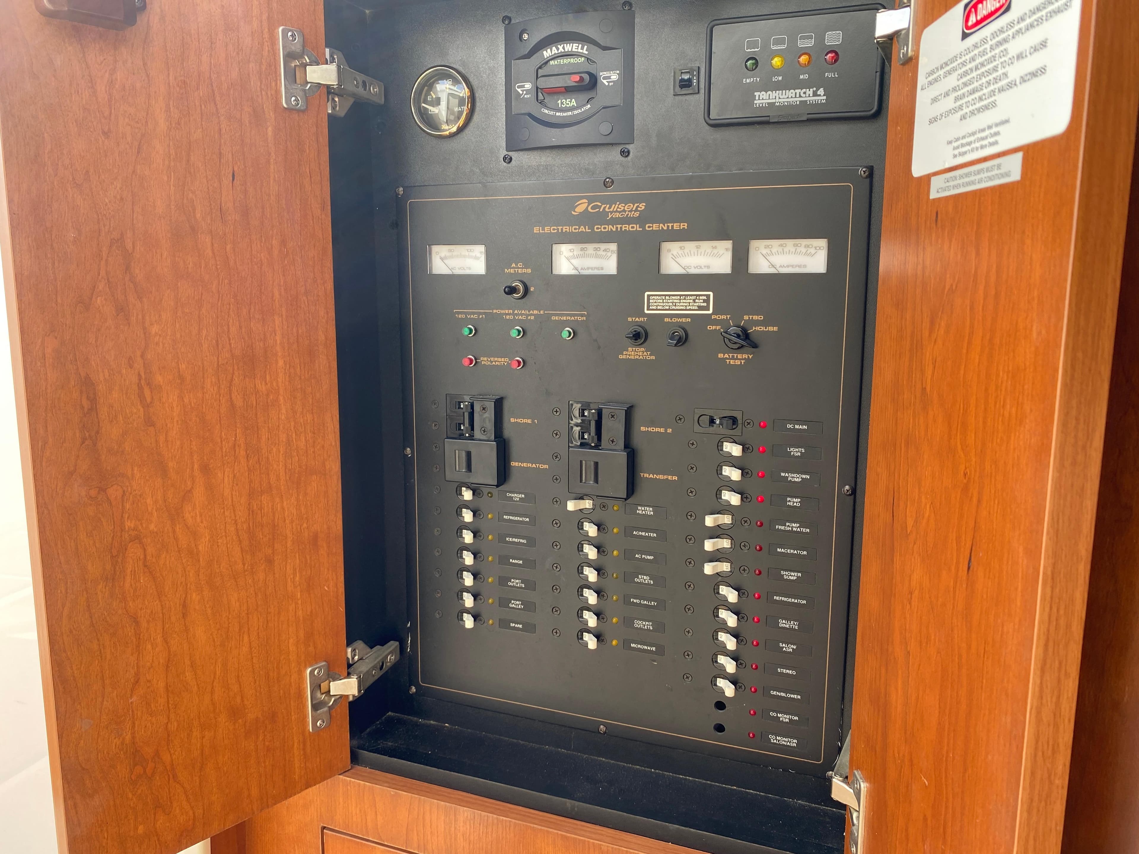 Electrical control panel inside a 2000 Cruisers 3672 boat, featuring switches and gauges.