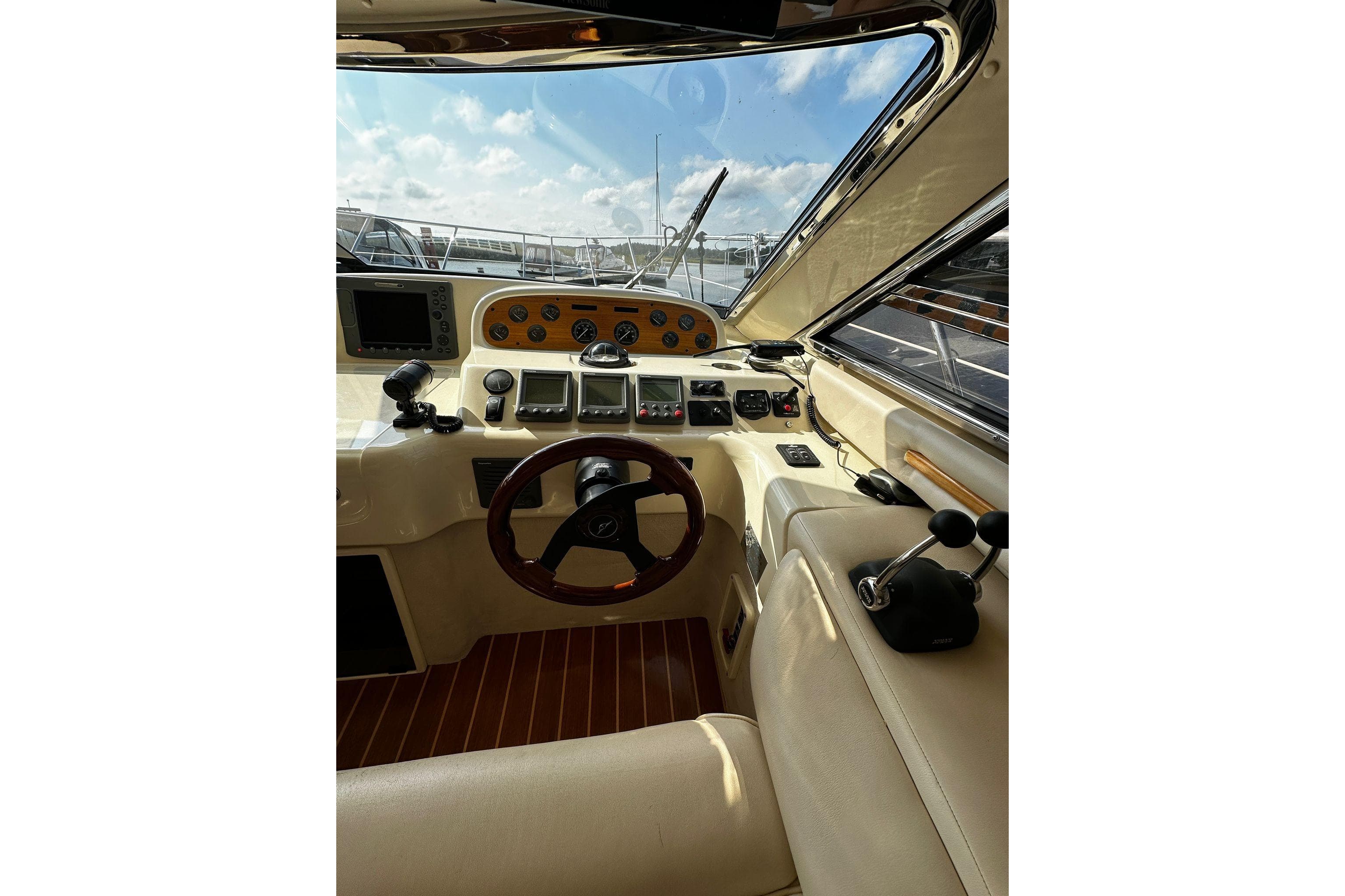 2006 Sealine F43 yacht cockpit with steering wheel and control panel.