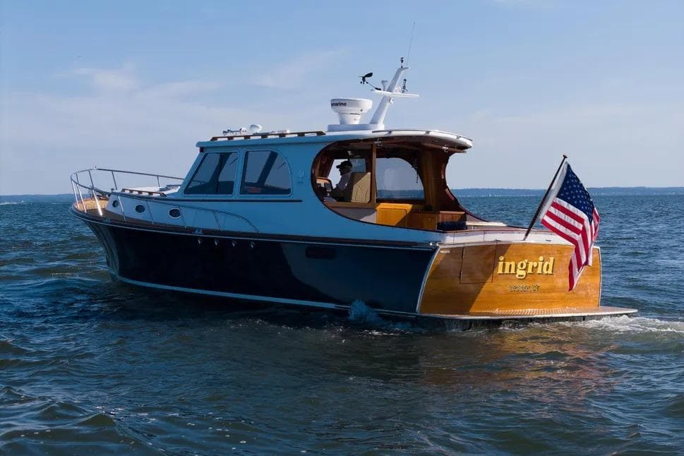 2007 Gorbon Custom Downeast 40 yacht cruising with American flag on open water.