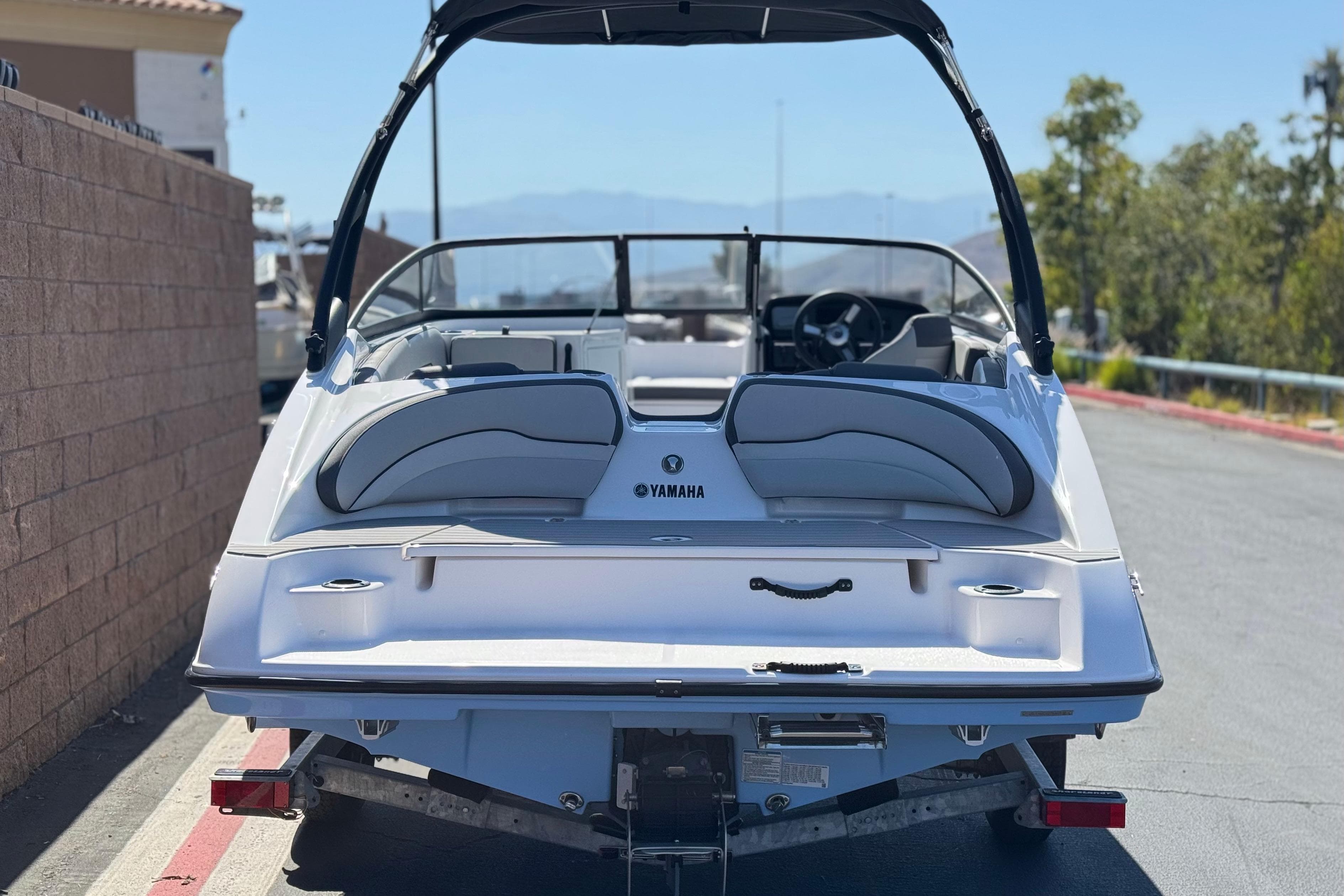 2025 Yamaha Boats AR190 on trailer, rear view, parked outdoors on sunny day.