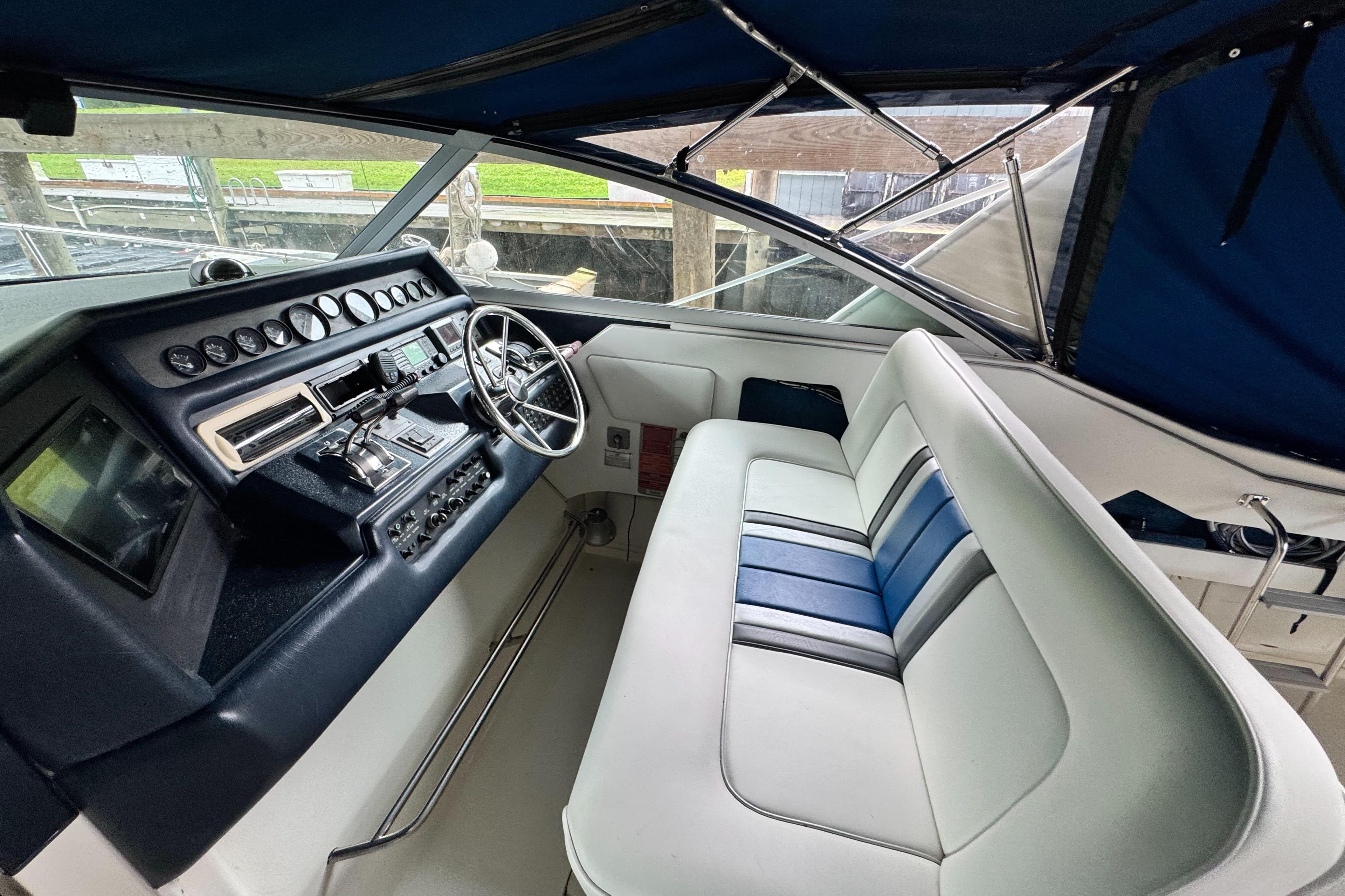 1990 Sea Ray 350 Express Cruiser cockpit with steering wheel and seating.