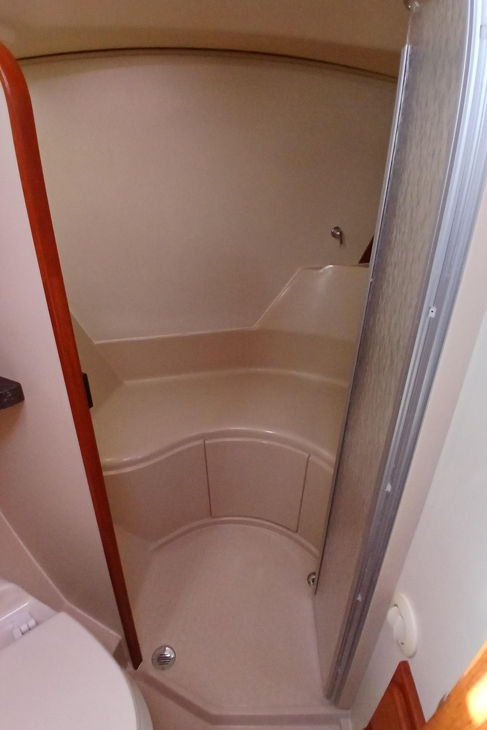 2006 Island Packet 440 yacht bathroom with curved shower and beige interior.