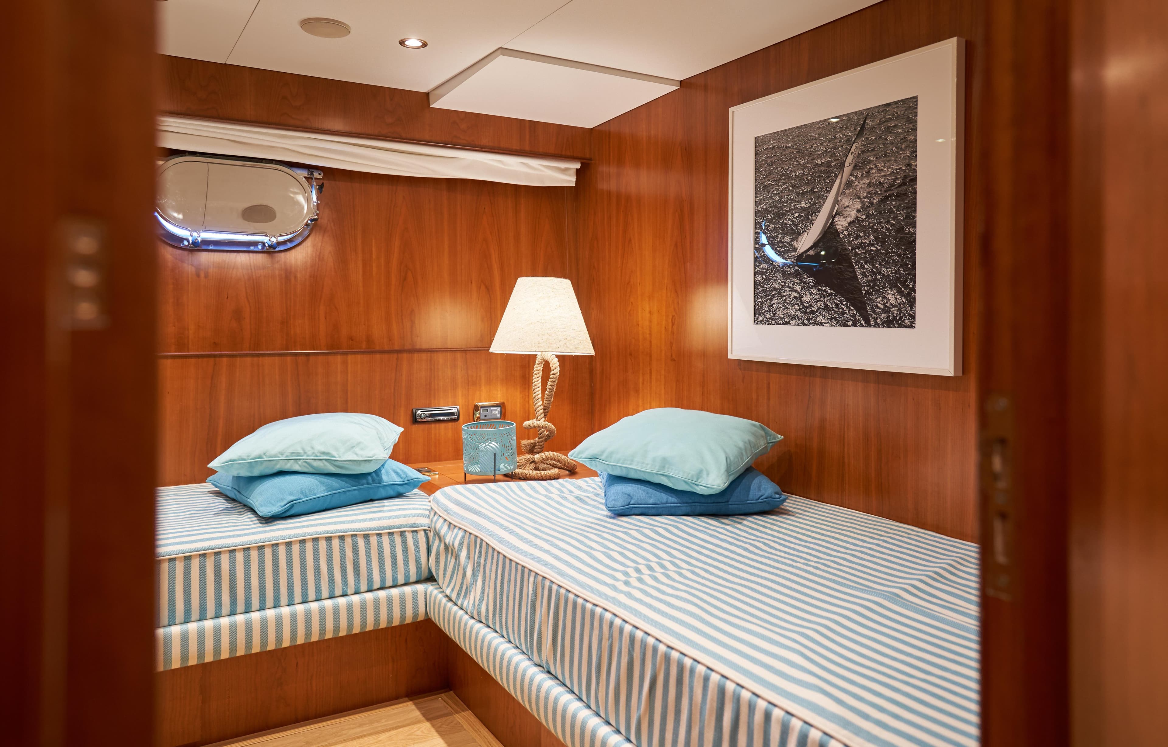 Twin cabin interior of 2009 Castagnola Navetta 33 yacht with striped bedding.