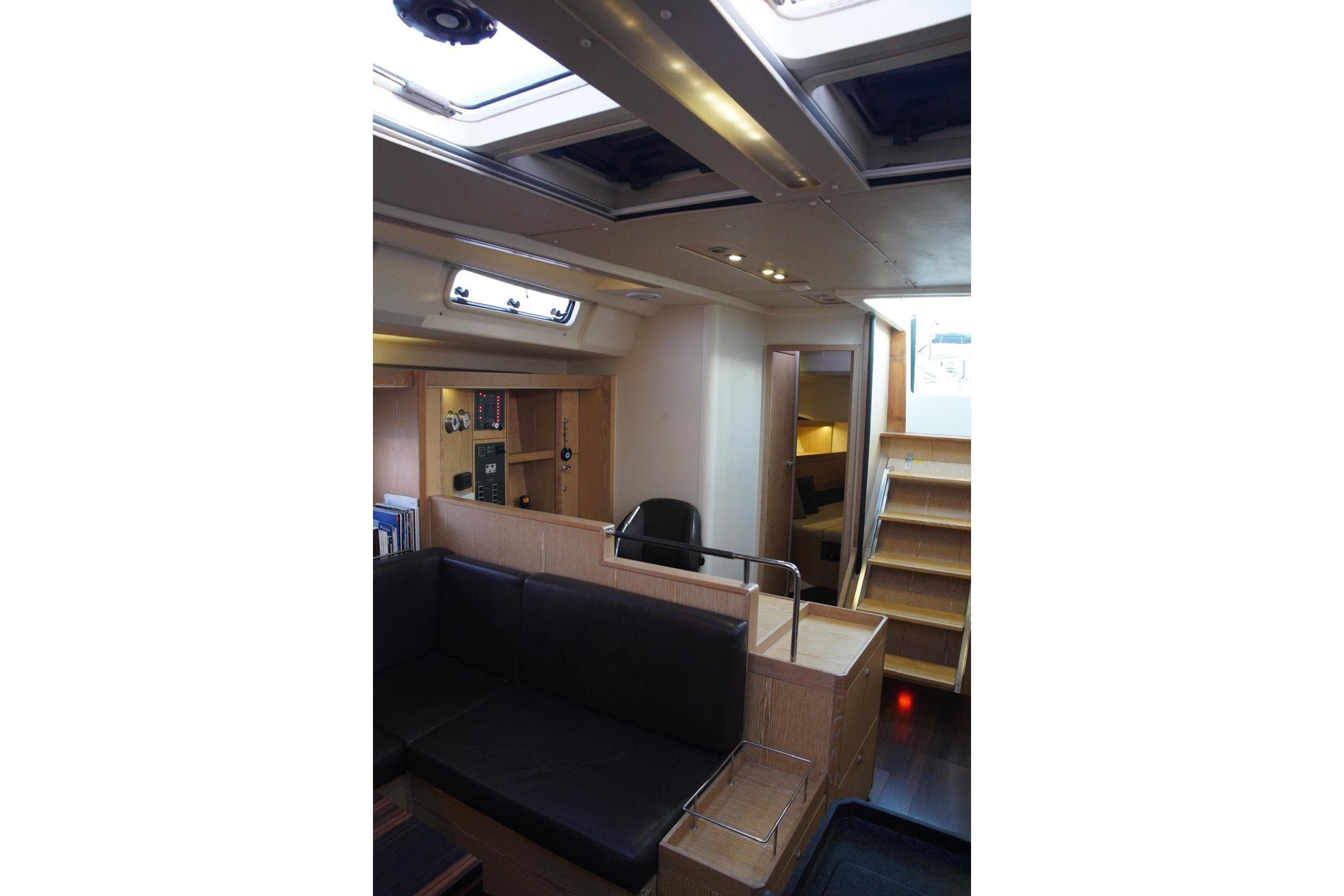 Interior of 2013 Hanse 575 yacht, featuring modern design with wooden finishes and seating area.