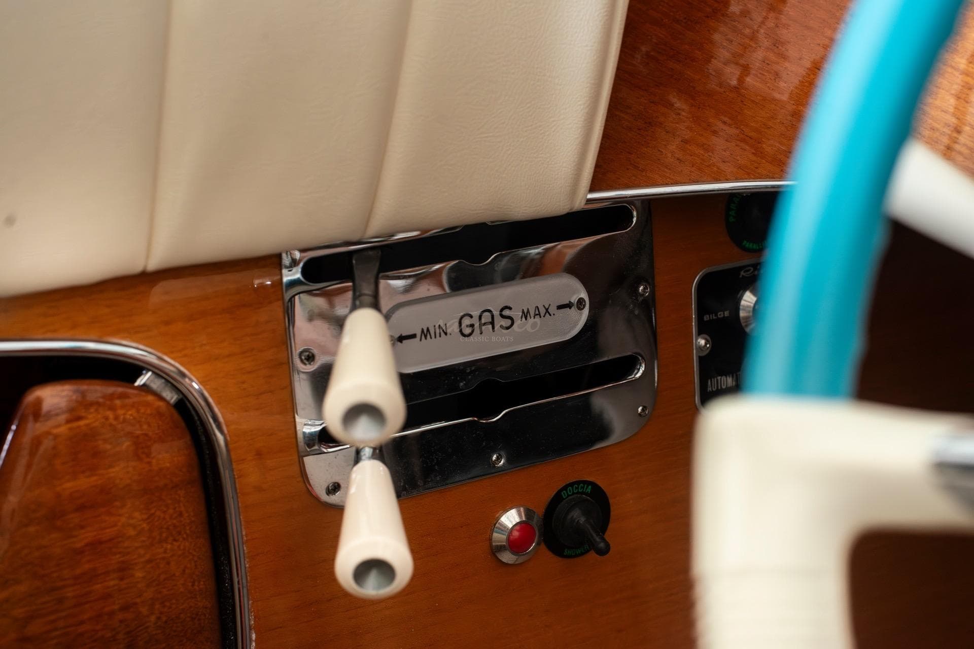1967 Riva Aquarama throttle controls with wooden dashboard and blue steering wheel.