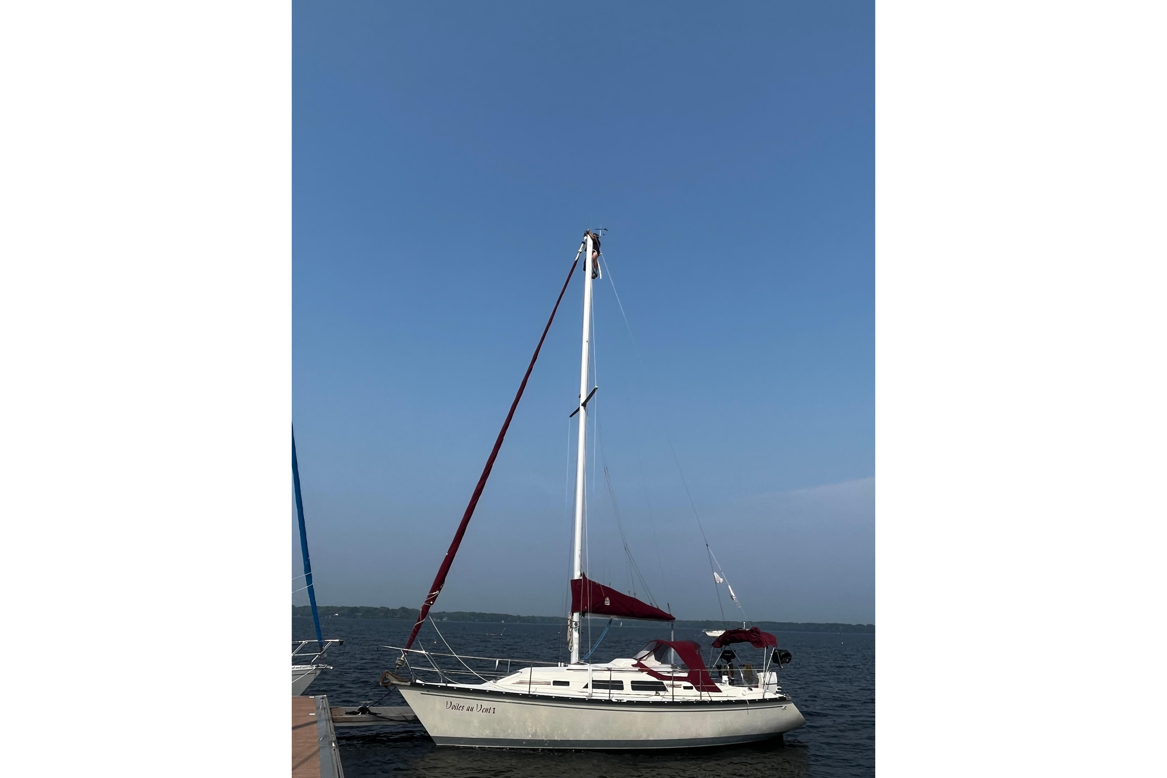 1988 Mirage 32 sailboat docked on calm water under clear blue sky.