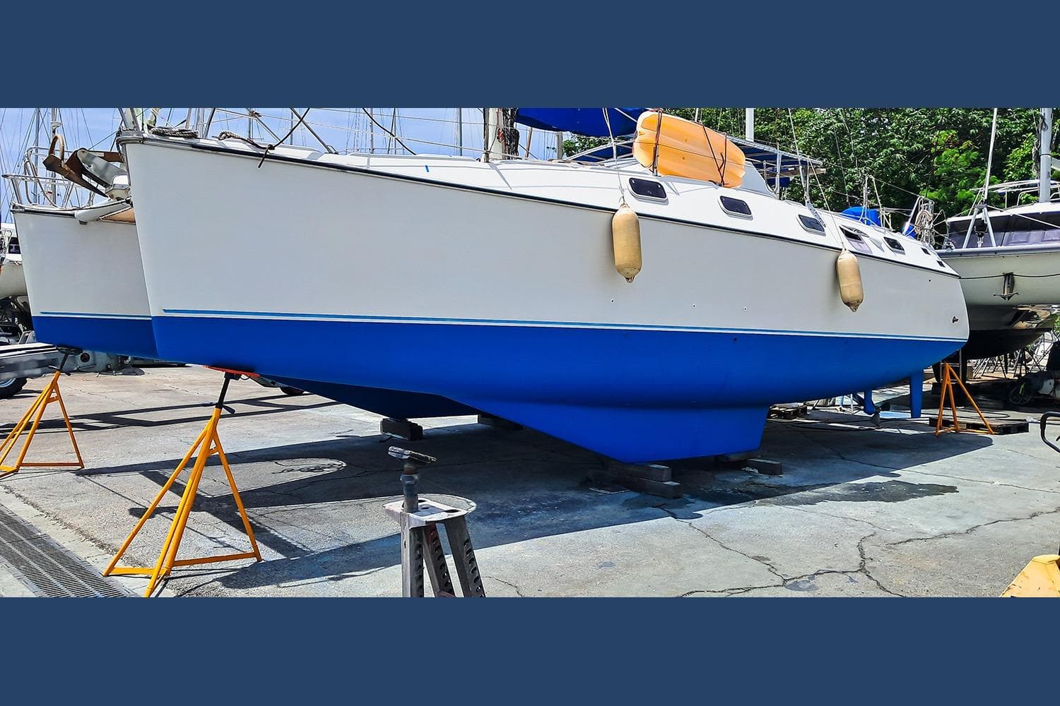 Catamaran Privilege 39, 1992 model, on dry dock with blue hull and white deck.