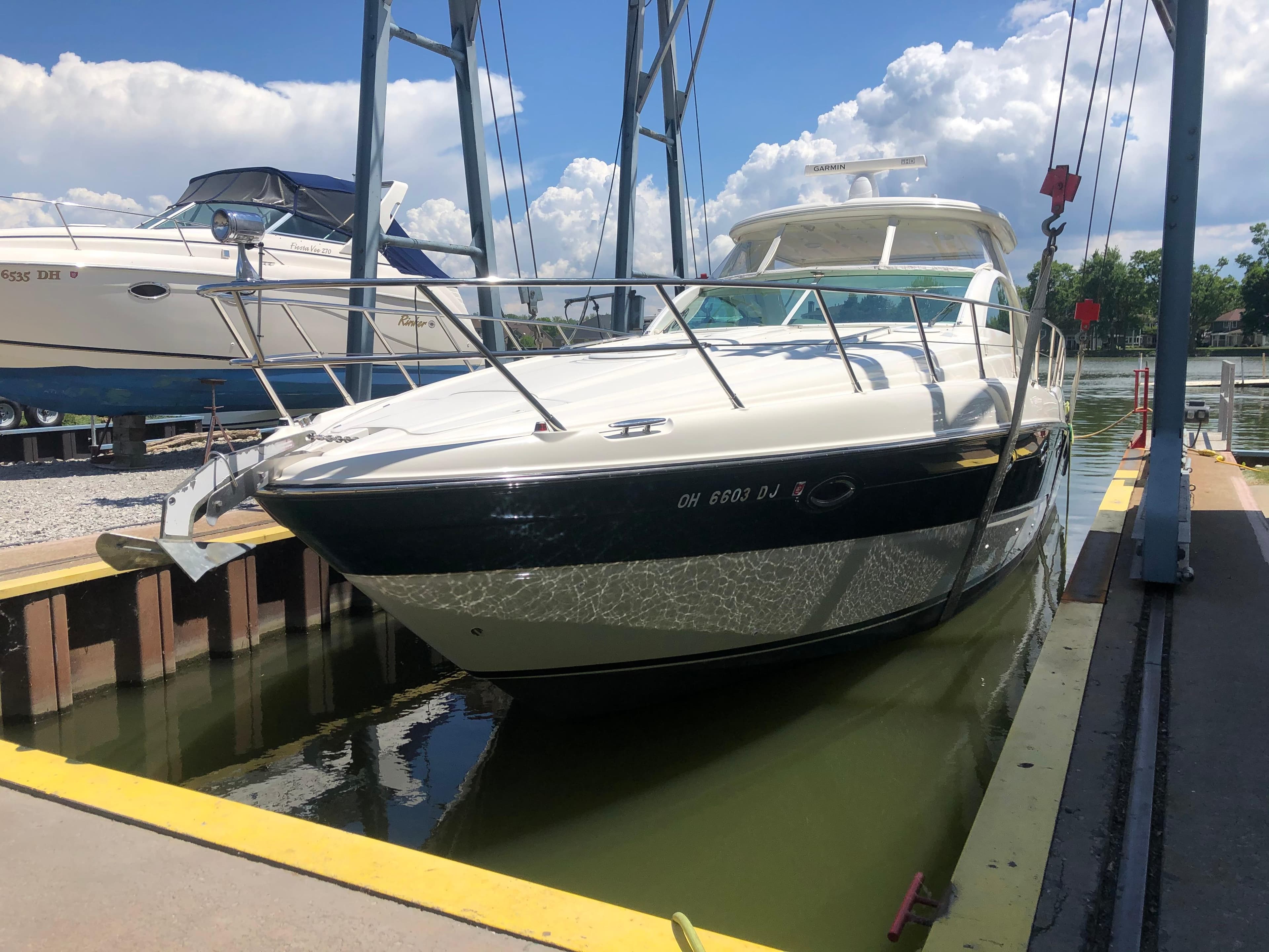 2002 Maxum 4200 SCR yacht docked at marina under blue sky.